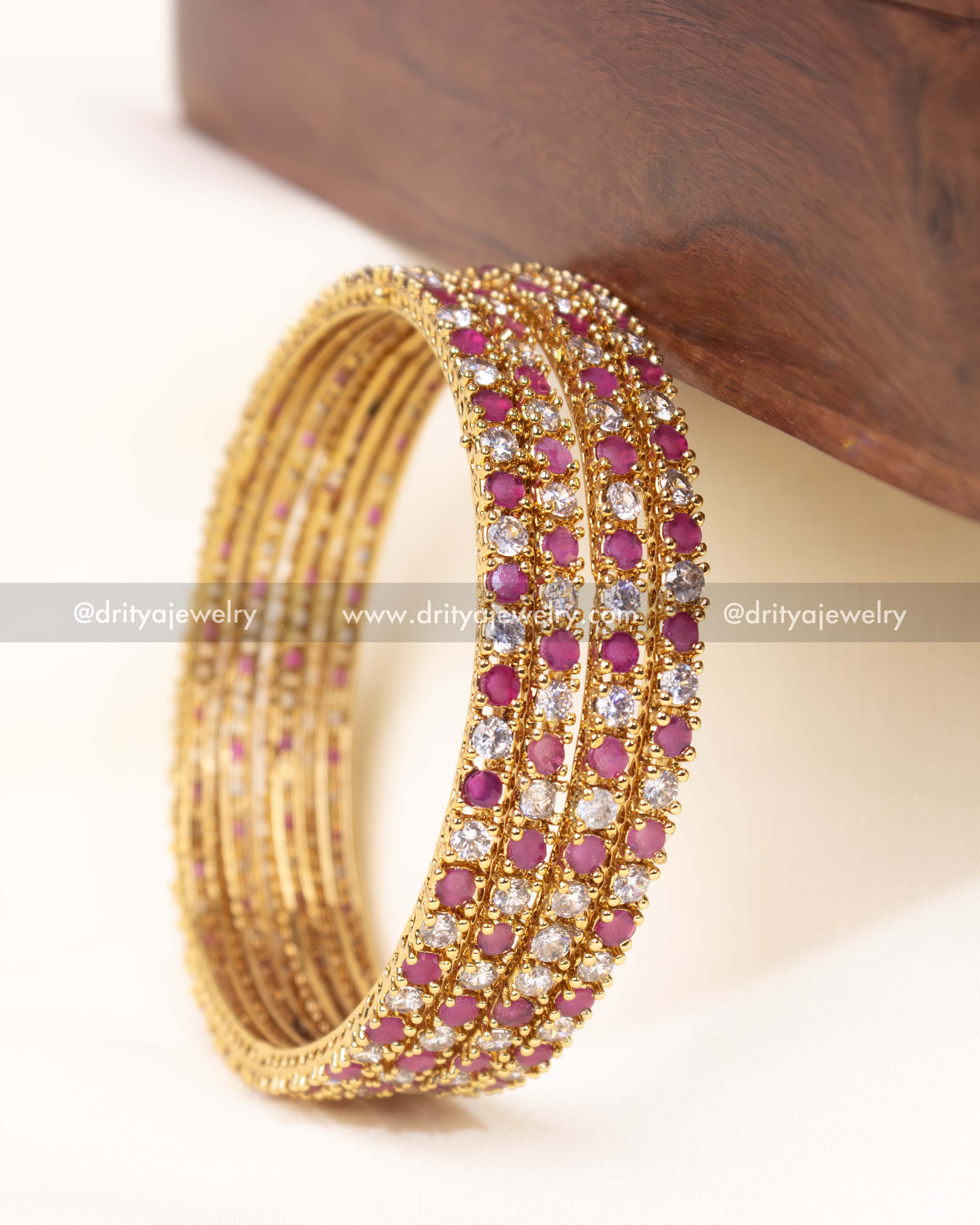 Graceful pink-accented CZ bangle set featuring a gold-plated finish, perfect for festive and bridal wear.