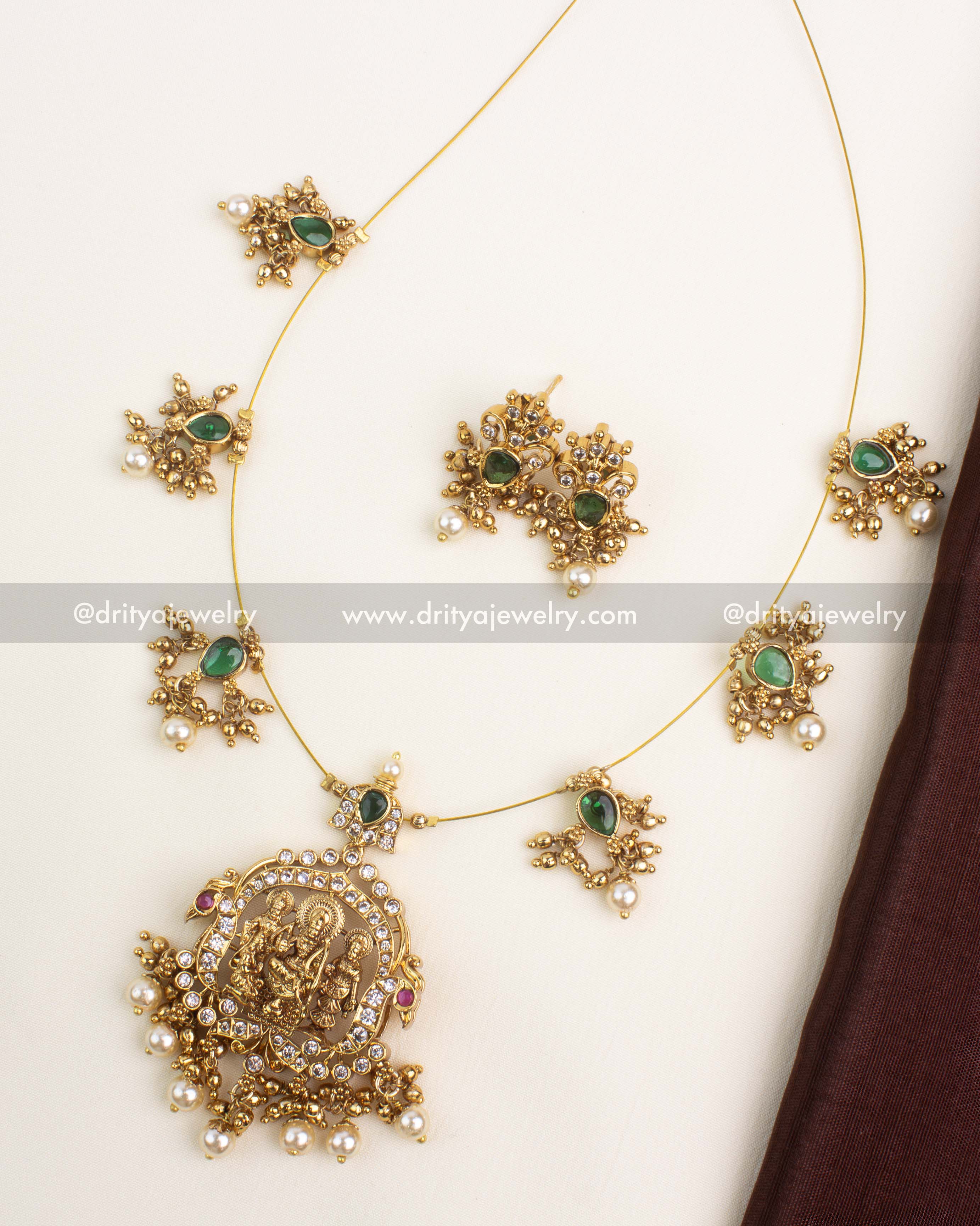 Temple-style Ram Parivar short necklace with emerald stones, pearls, and gold plating.