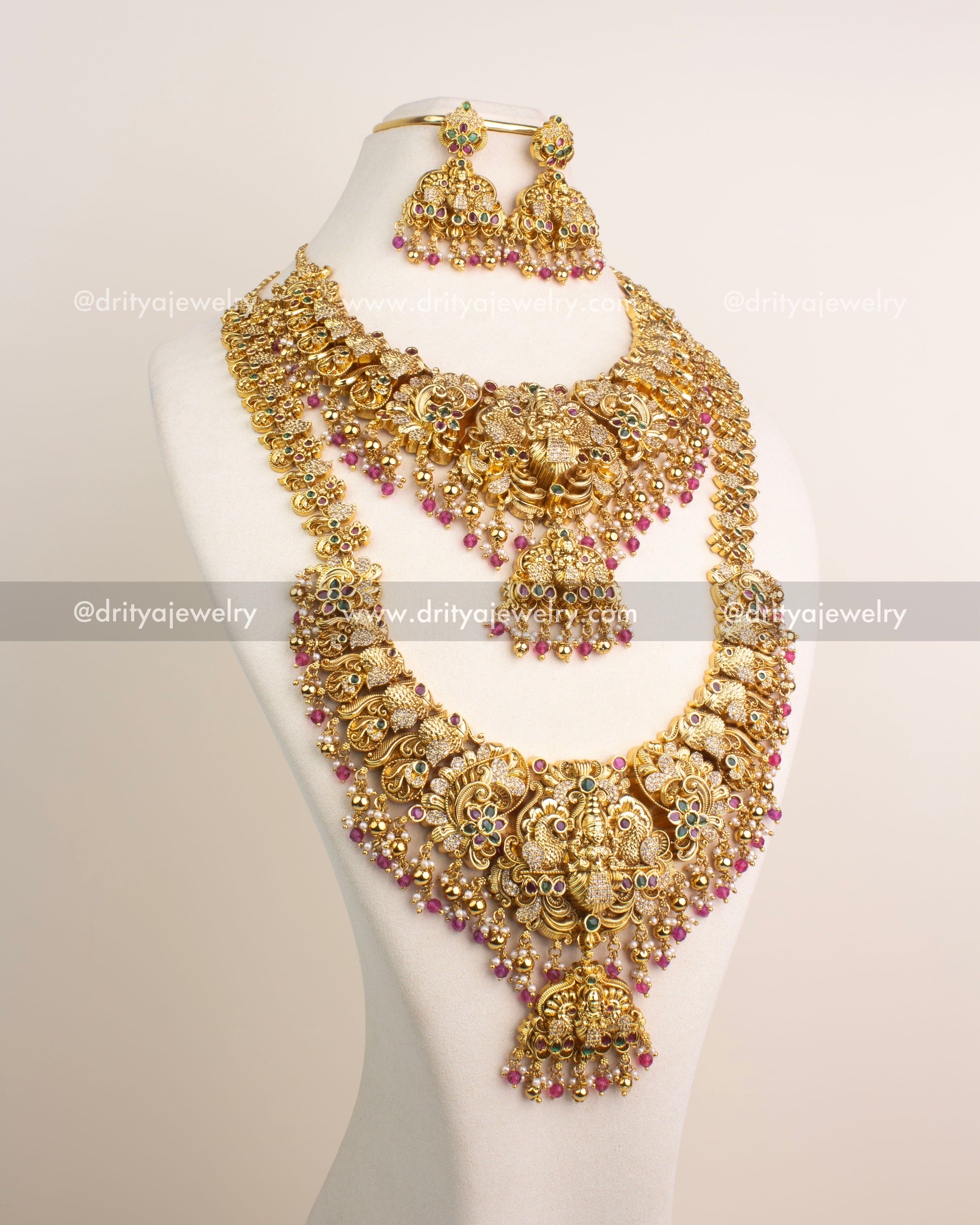 Antique gold temple bridal jewelry set featuring Lakshmi motifs, CZ stone accents, and ruby pink bead drops.