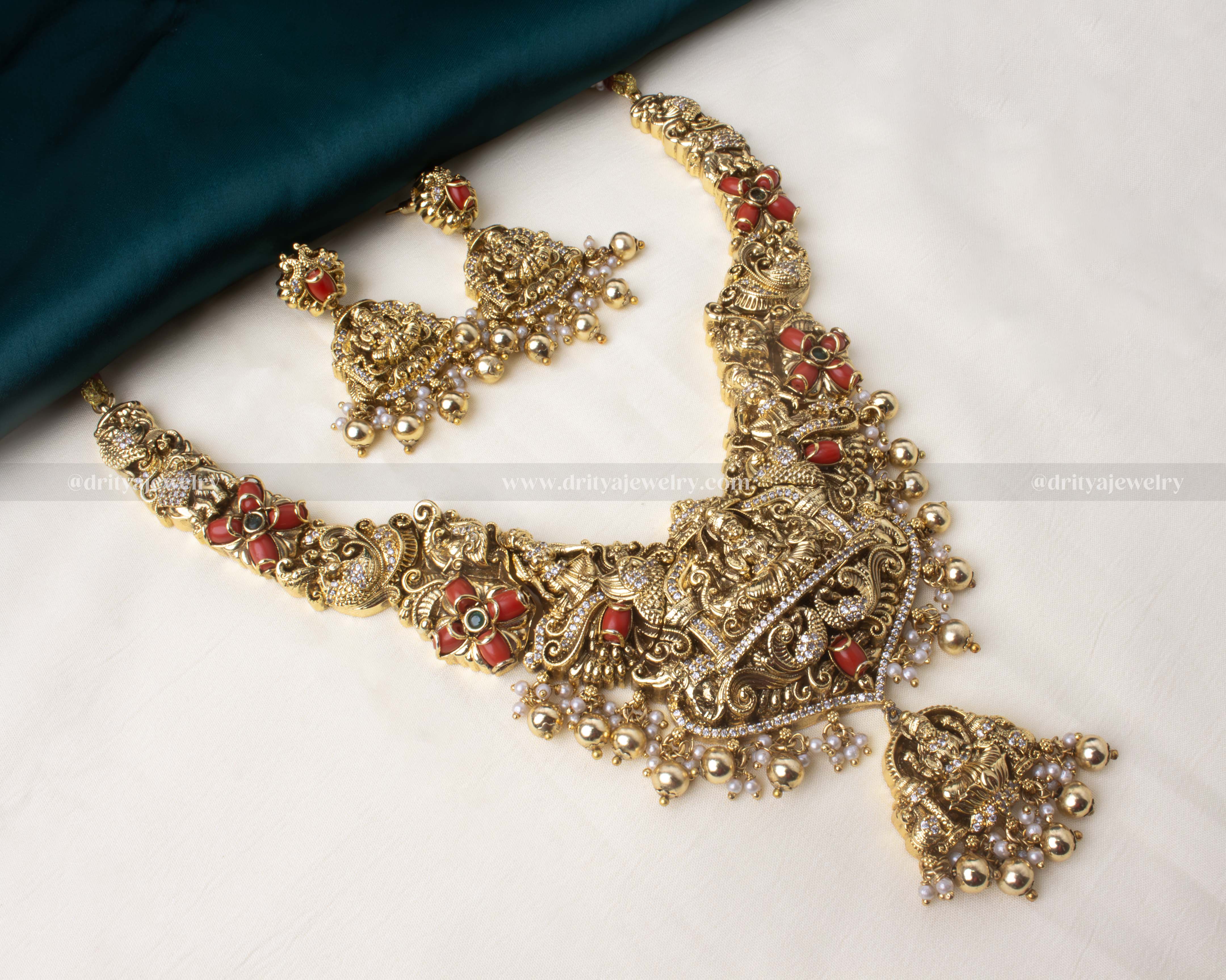 Grand temple necklace set featuring goddess motifs, red enamel accents, and matching earrings.