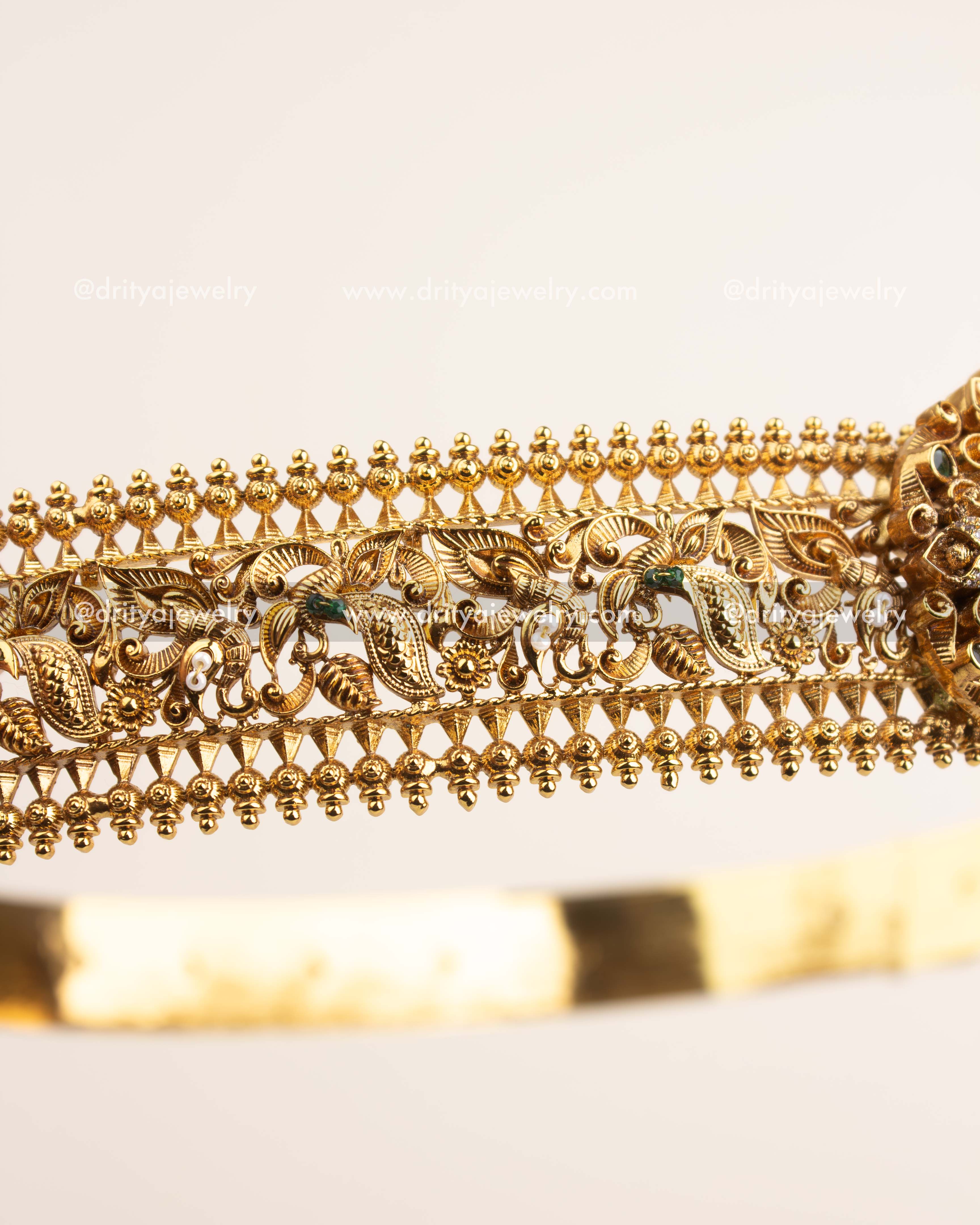 Side view showcasing intricate filigree foliage and bead edge design in antique gold polish.
