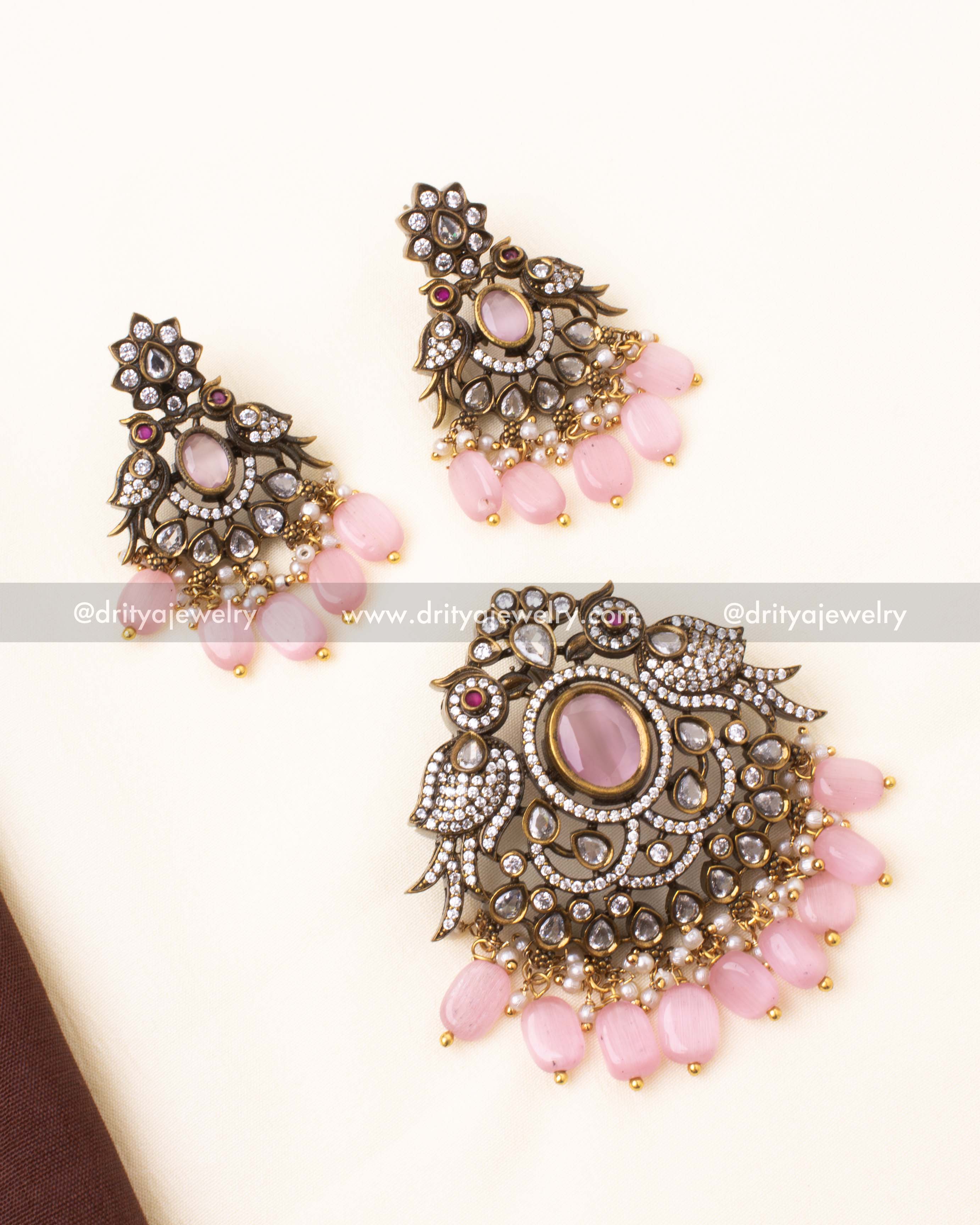 Elegant Victorian-style pendant set with matching earrings featuring pink stones and bird motifs.