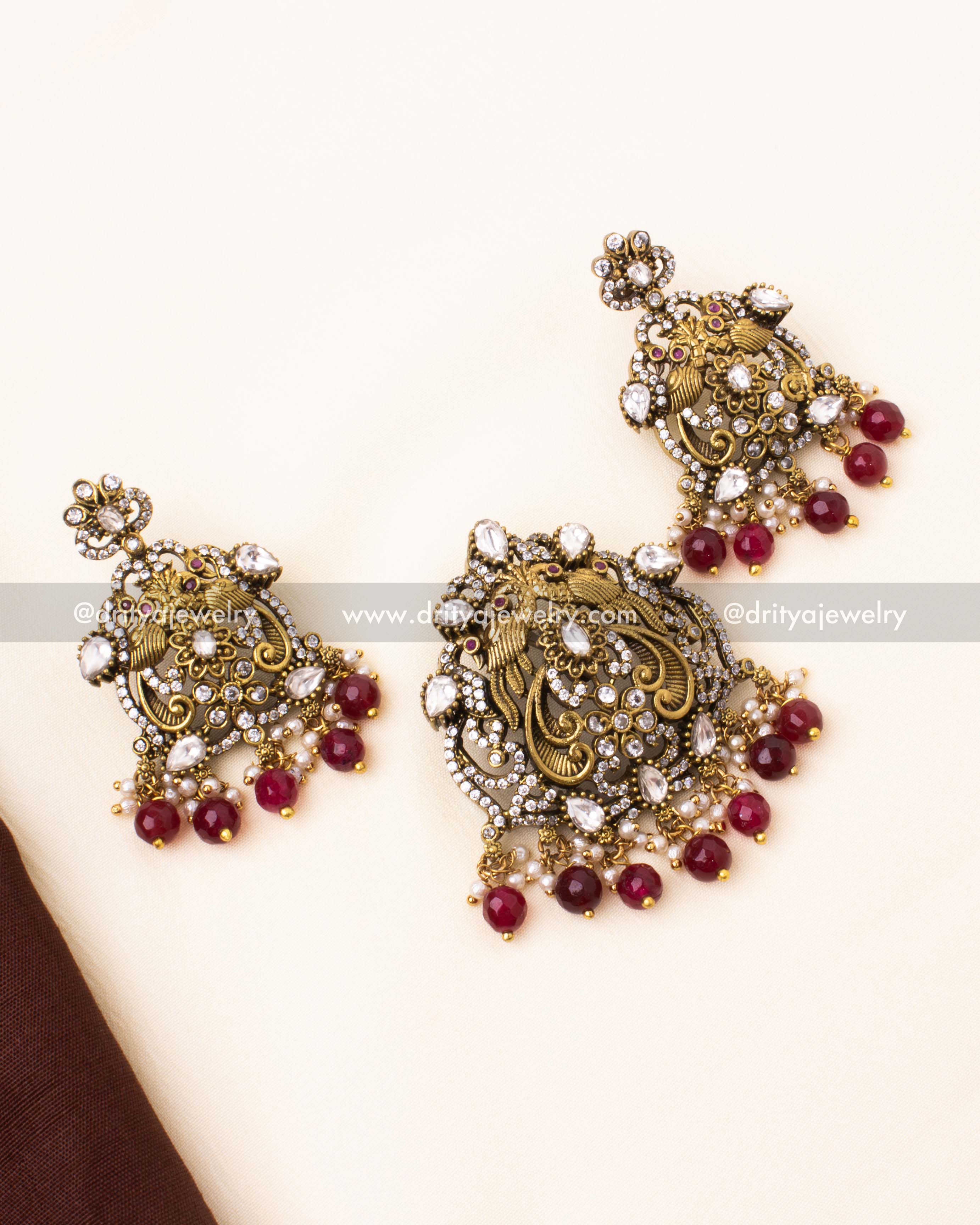 Regal Victorian-style pendant set adorned with polki stones, ruby beads, and pearls in an antique gold finish.