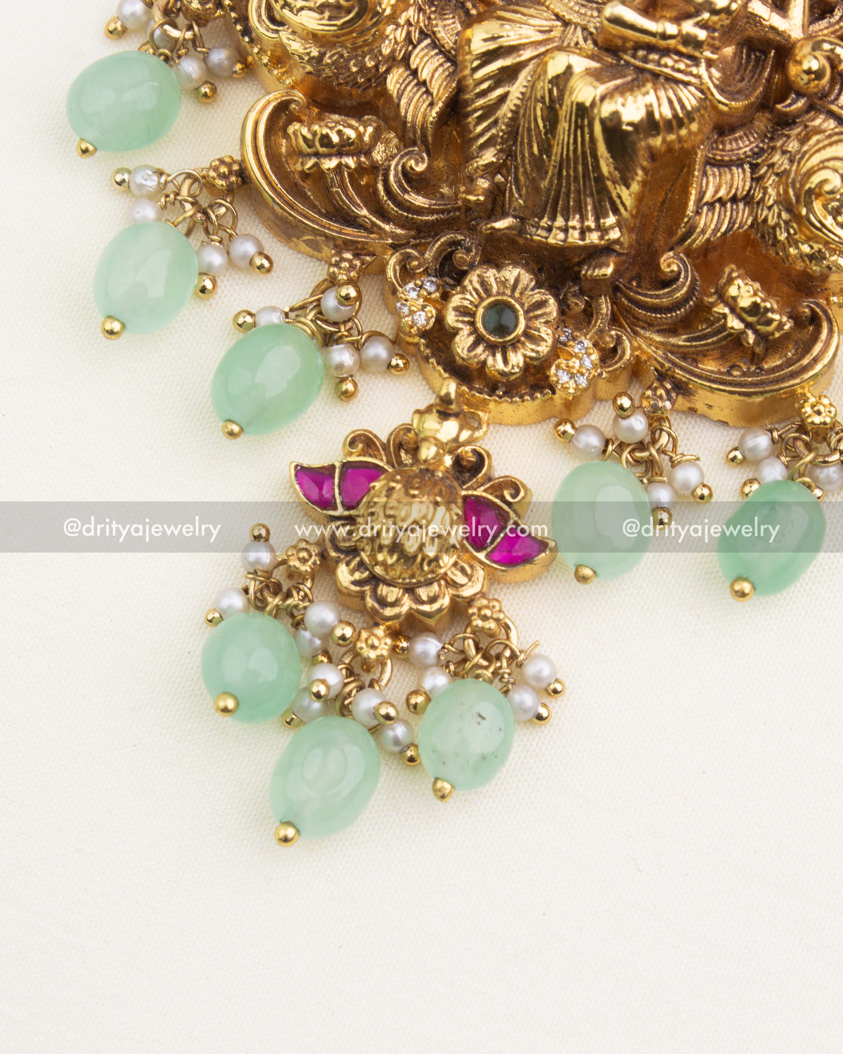 Close-up of Radha Krishna temple pendant showcasing nakshi detailing, CZ stones, kemp enamel work, and mint-green bead drops.