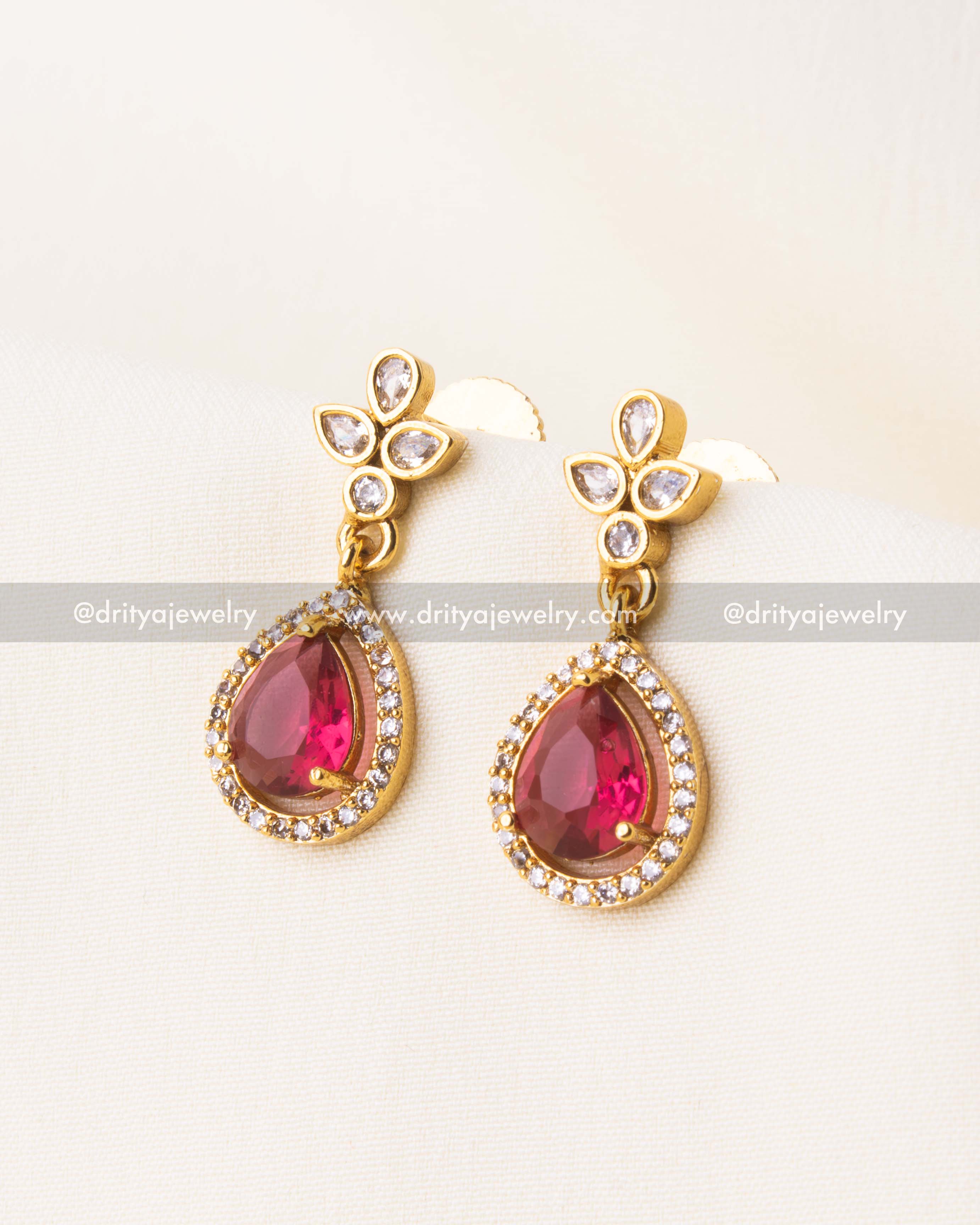 Elegant red gemstone earrings with gold floral tops.