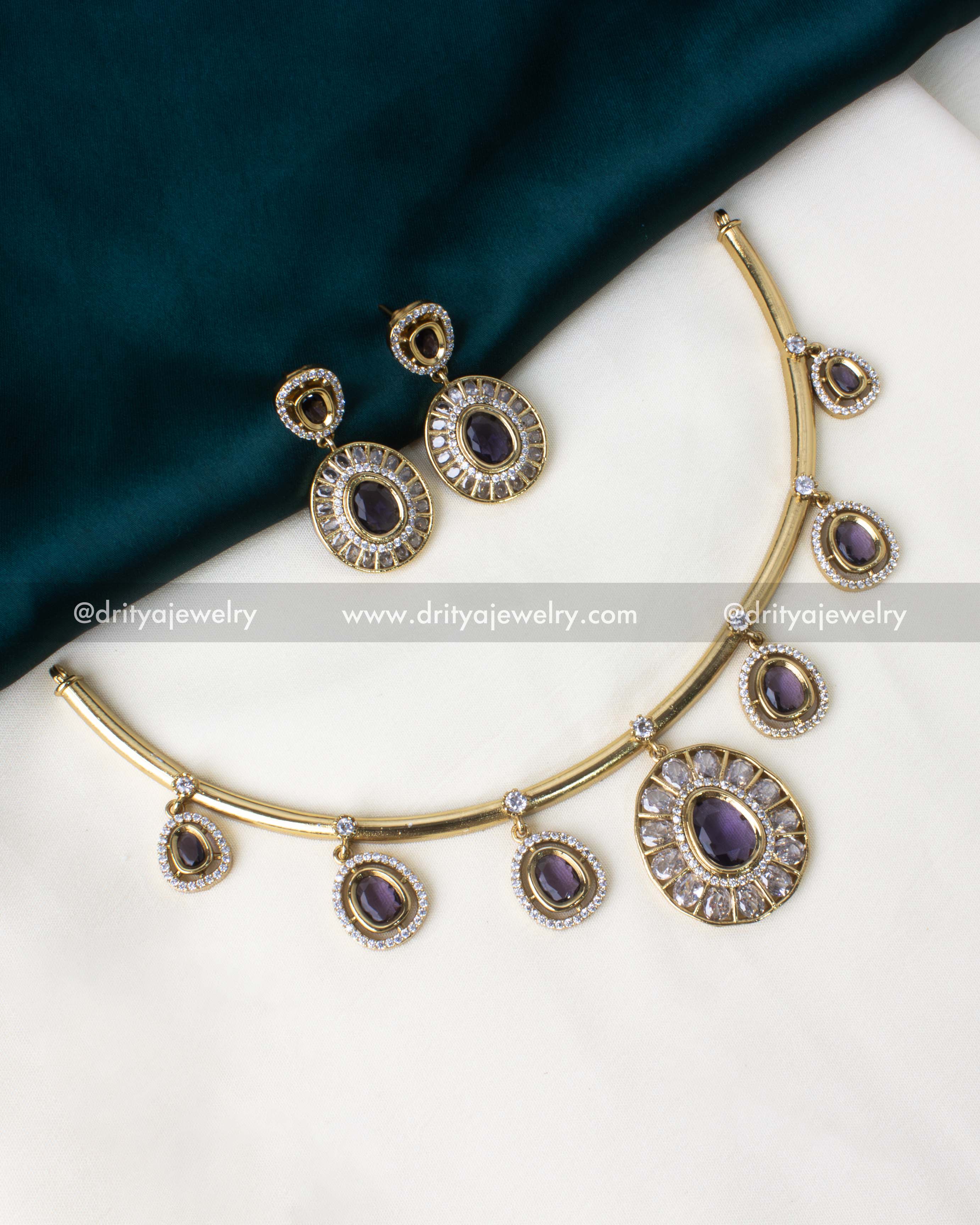 Gold-plated hasli necklace set with deep purple pendants and AD stone details.