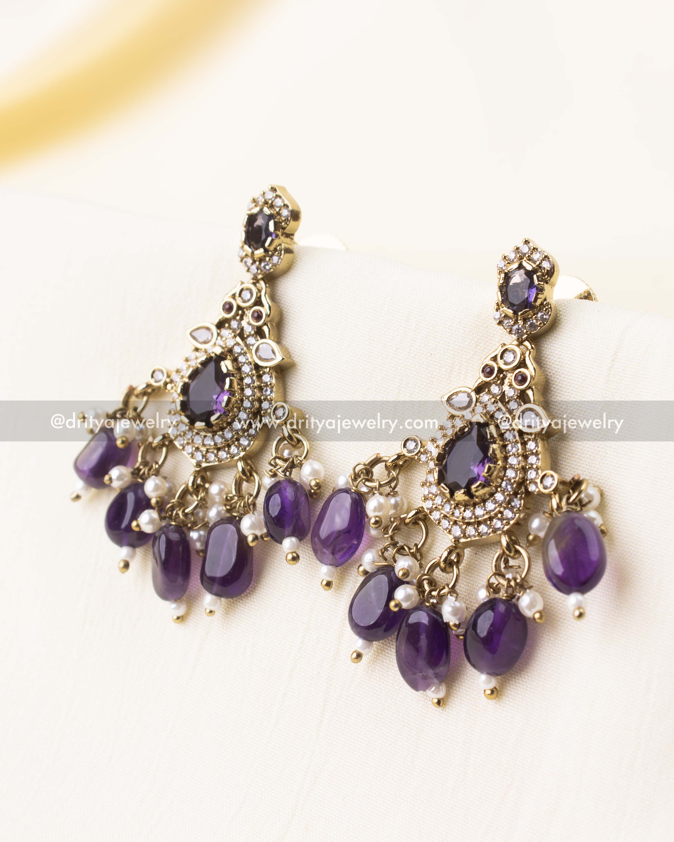 Detailed view of purple teardrop beads and vintage stone design.