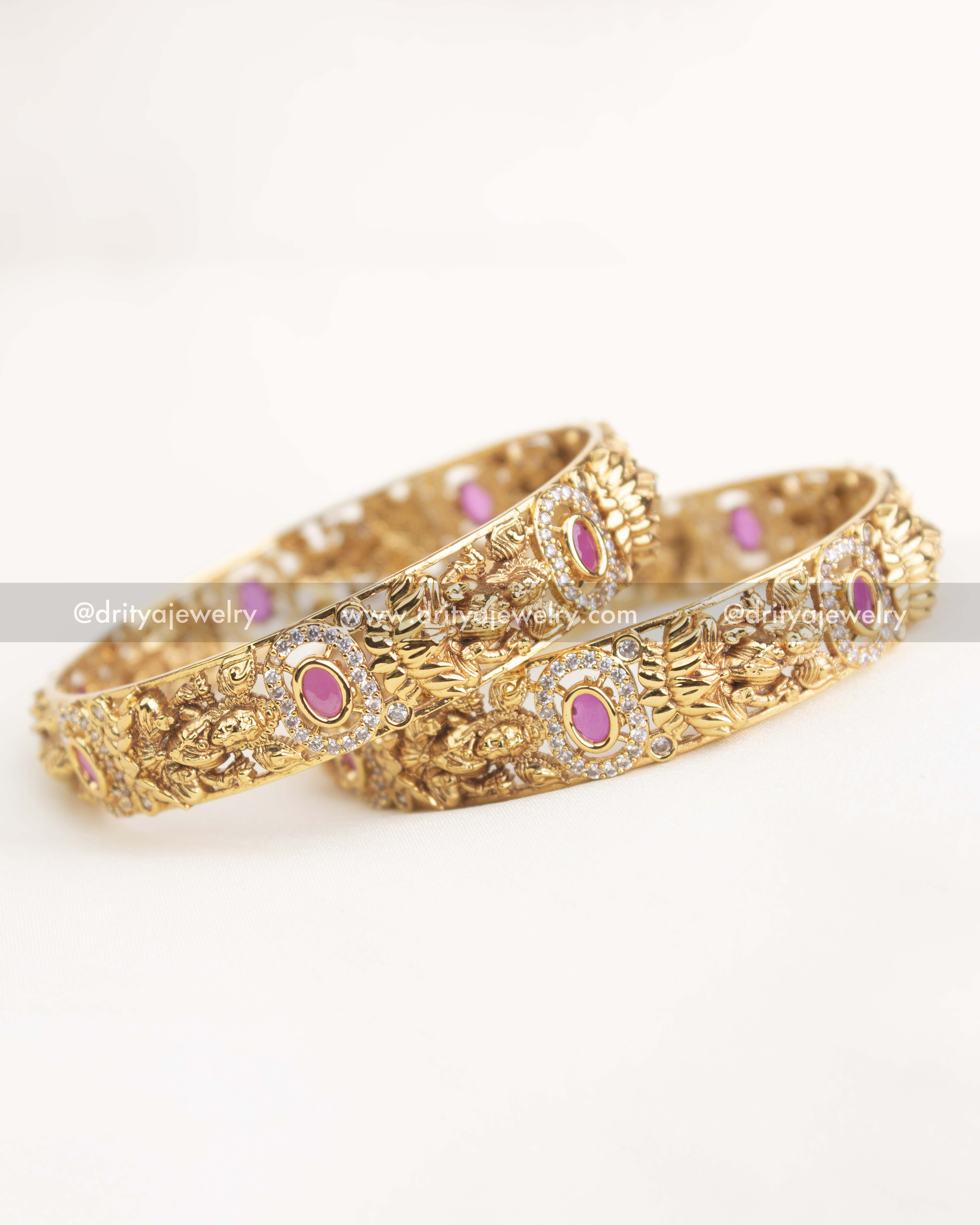 Gold temple bangles featuring ruby pink stones, goddess carvings, and AD stone embellishments
