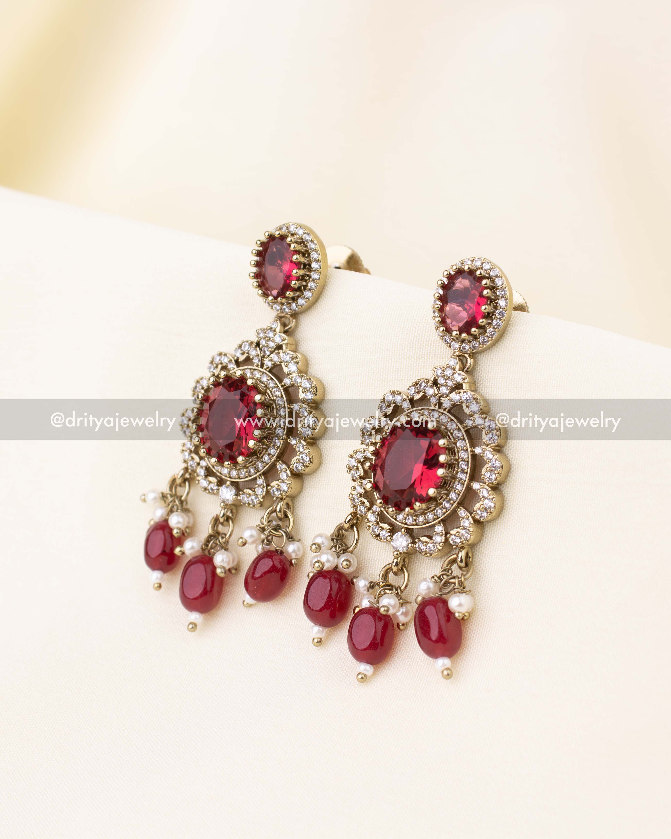 Elegant earrings with ruby red stones and bead drops.