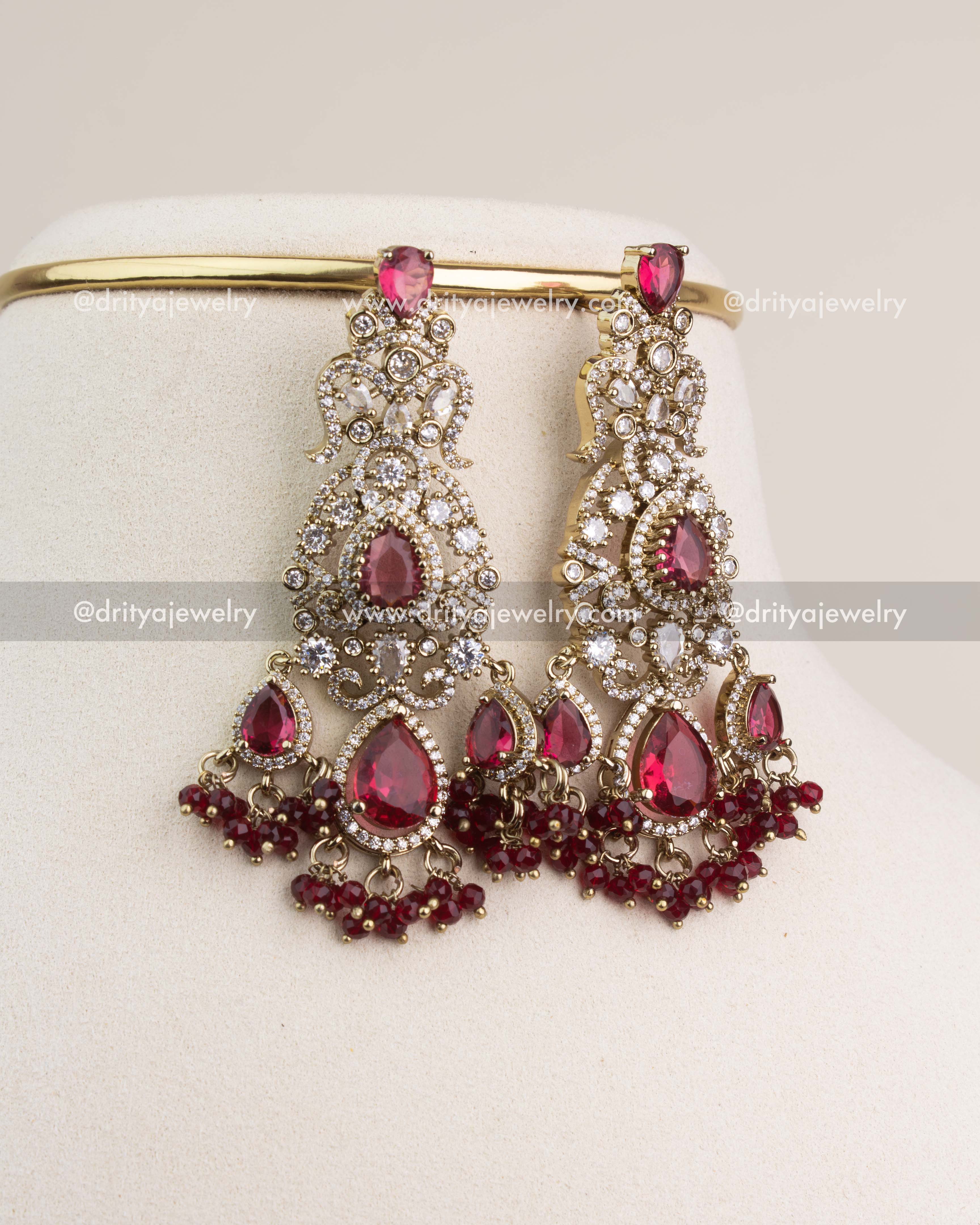 Large Victorian-style bridal danglers with ruby red teardrop stones and white CZ detailing.