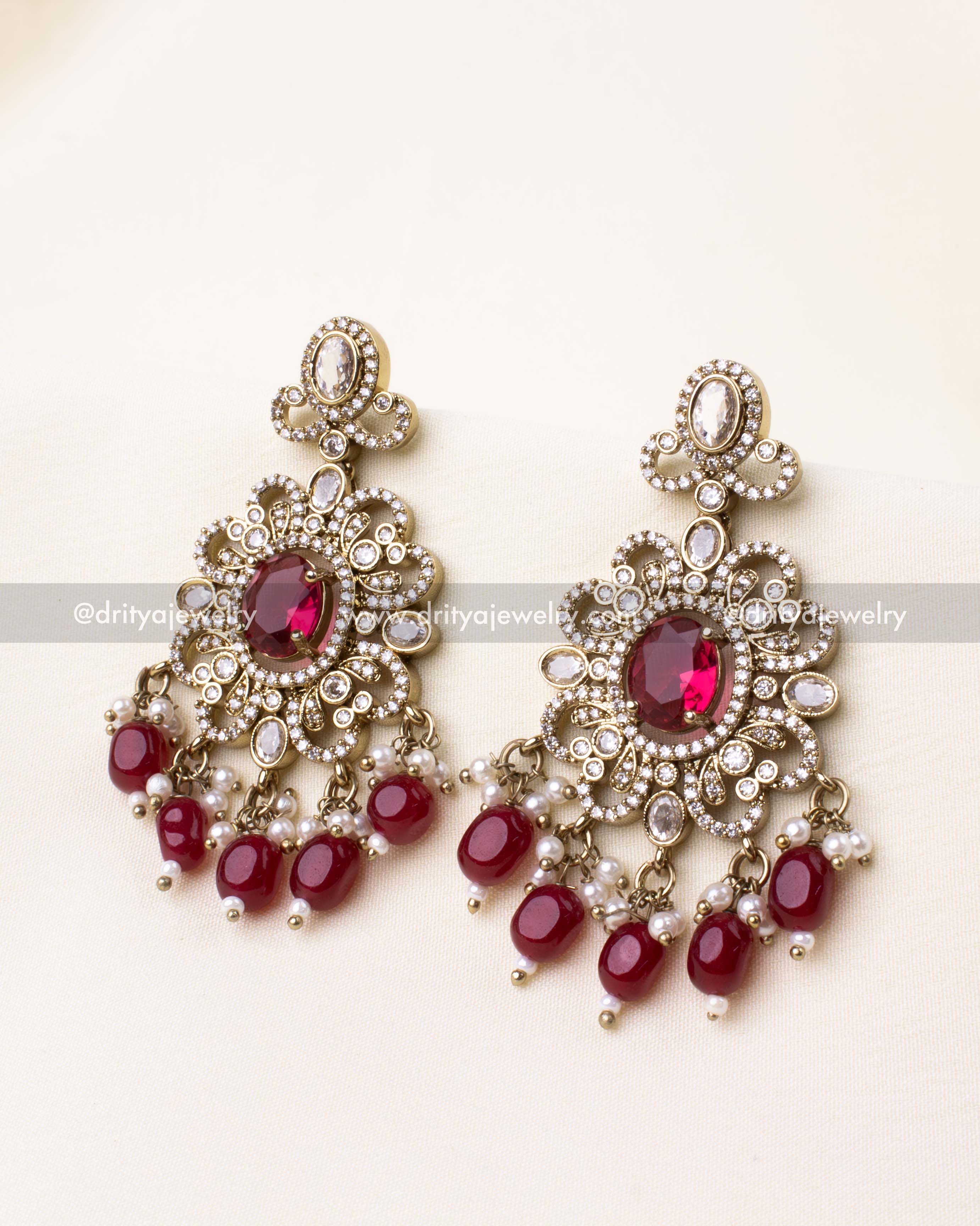 Elegant ruby red Victorian earrings with intricate floral detailing and hanging beads.