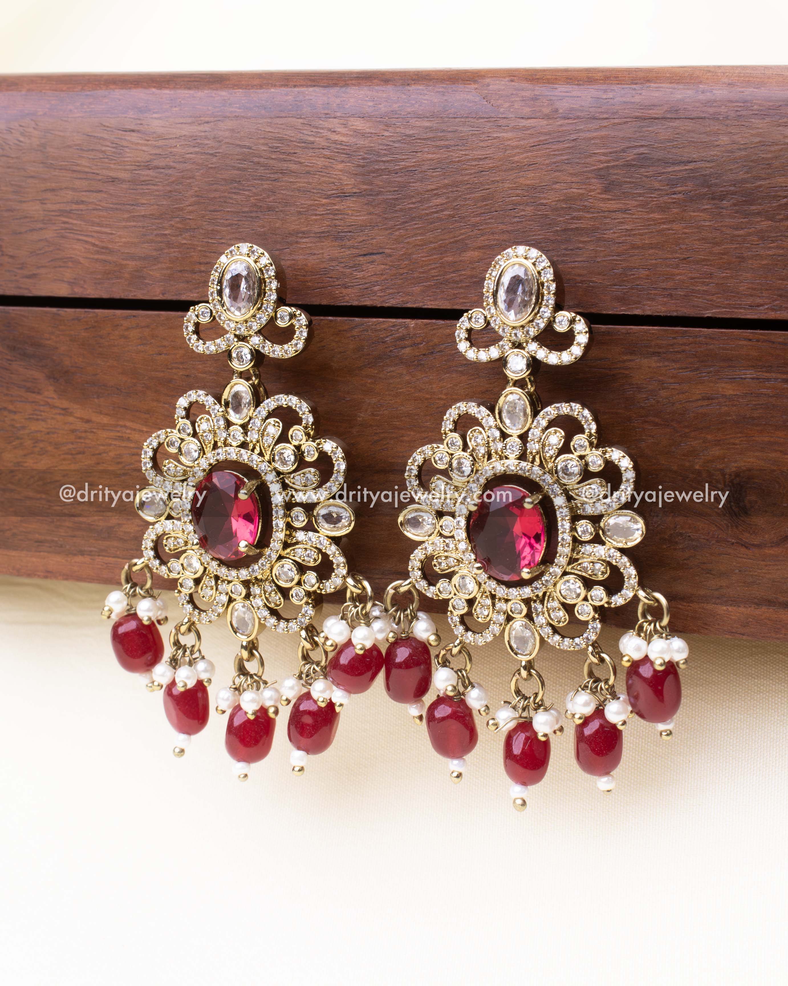 Antique-style earrings in ruby red with CZ stone accents and bead drops.