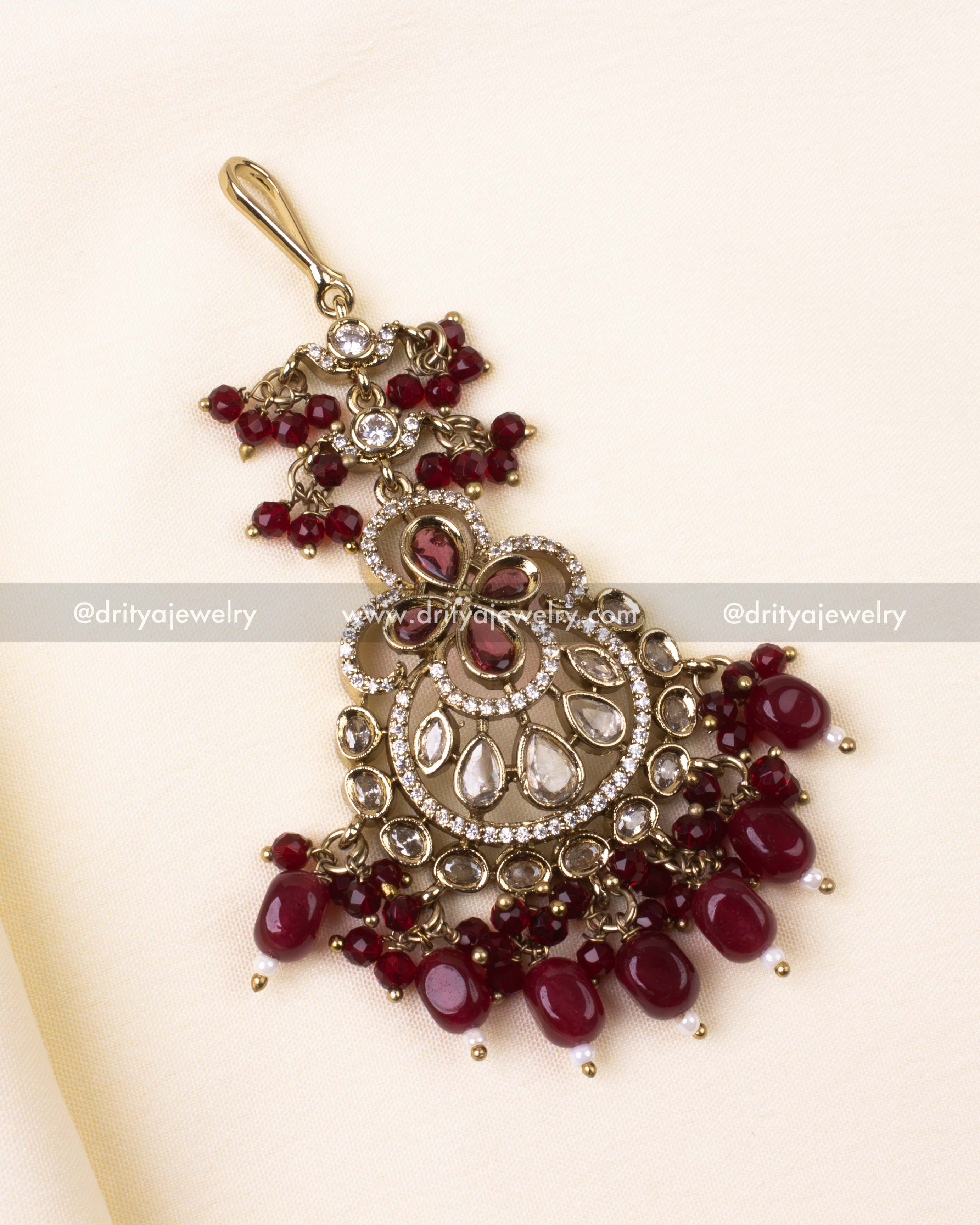 Victorian-inspired tikka with ruby red stones and elegant bead fringe.