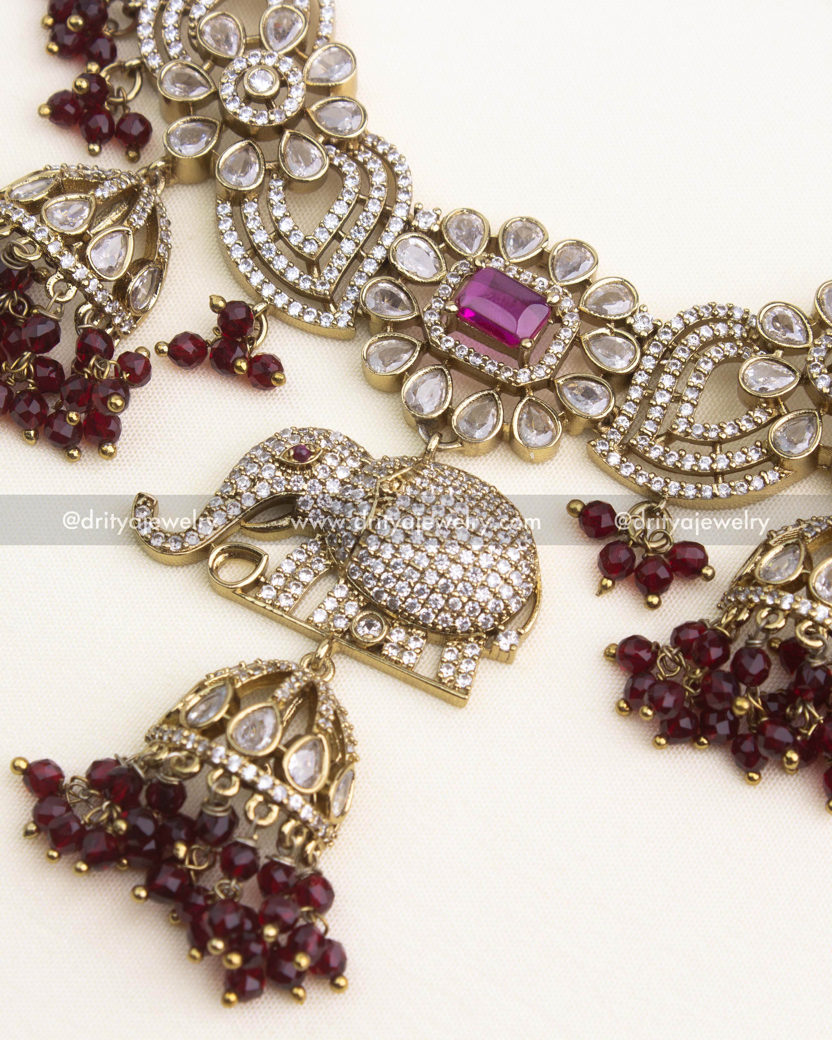 Close-up of ruby Victorian short necklace featuring elephant motif, floral patterns, and CZ detailing.