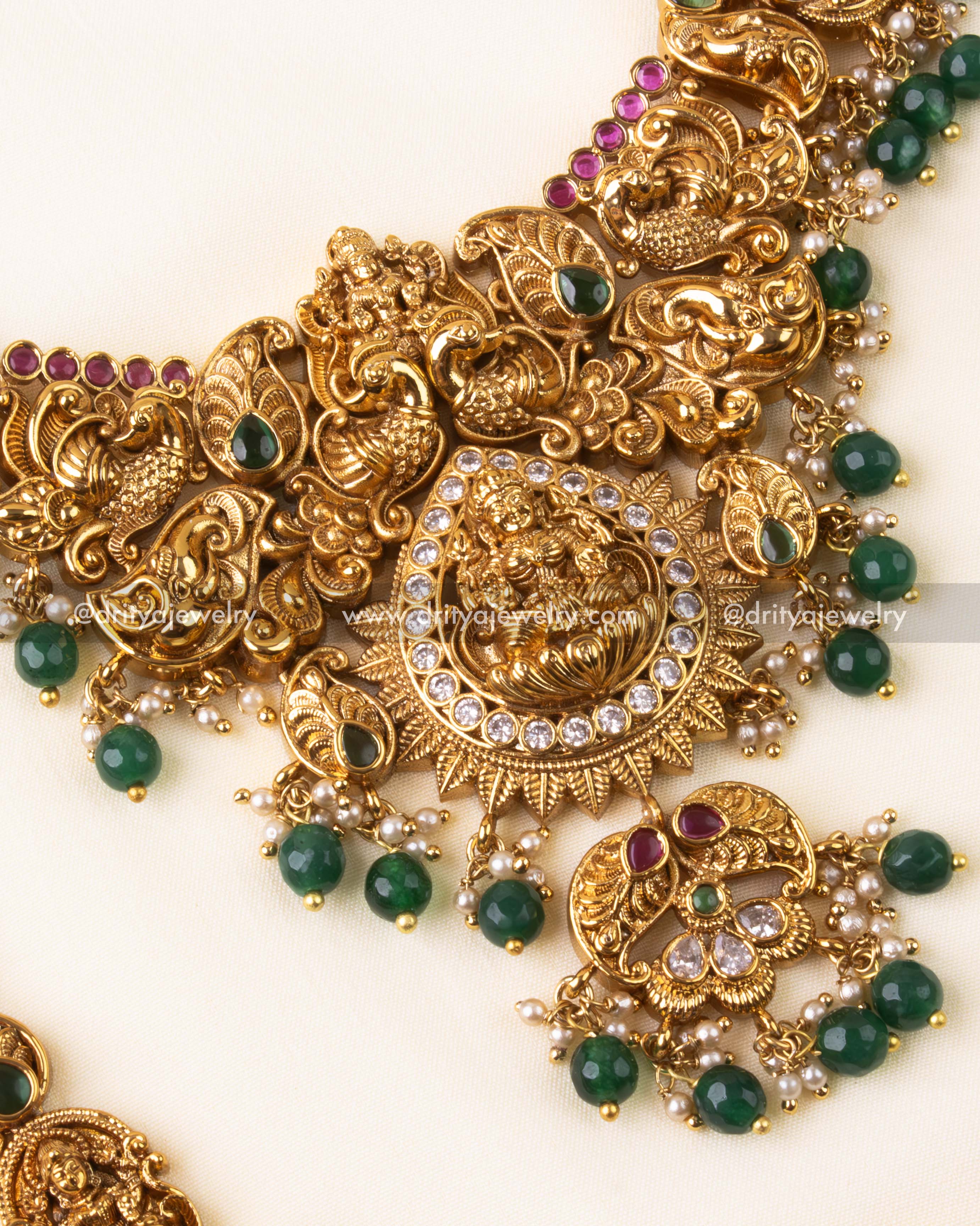 Close-up of short necklace with Lakshmi Devi pendant and intricate gold finish.