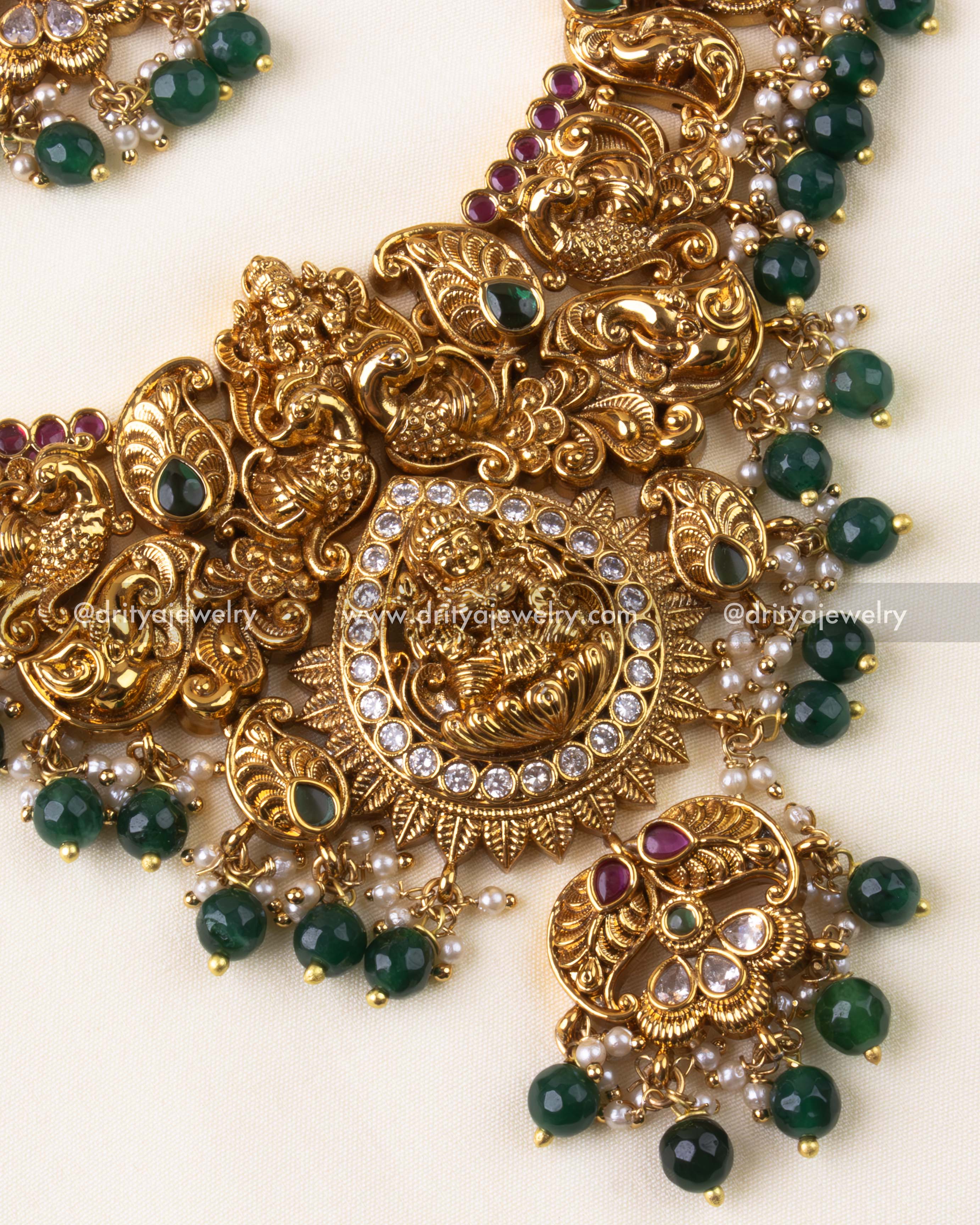 Close-up of short necklace with Lakshmi Devi pendant and intricate gold finish.