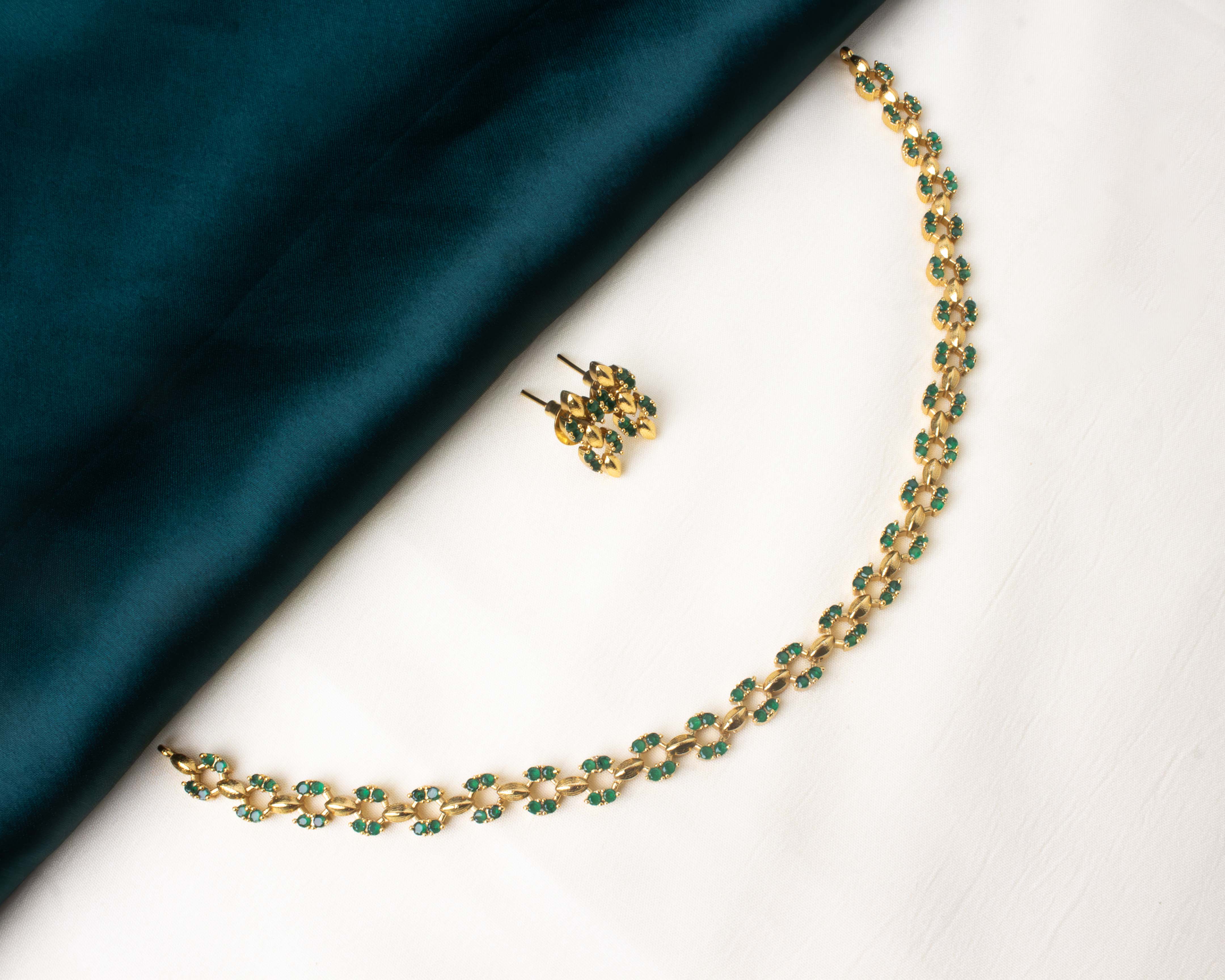 Stylish short necklace set featuring pink AD stones and a gold-tone finish.