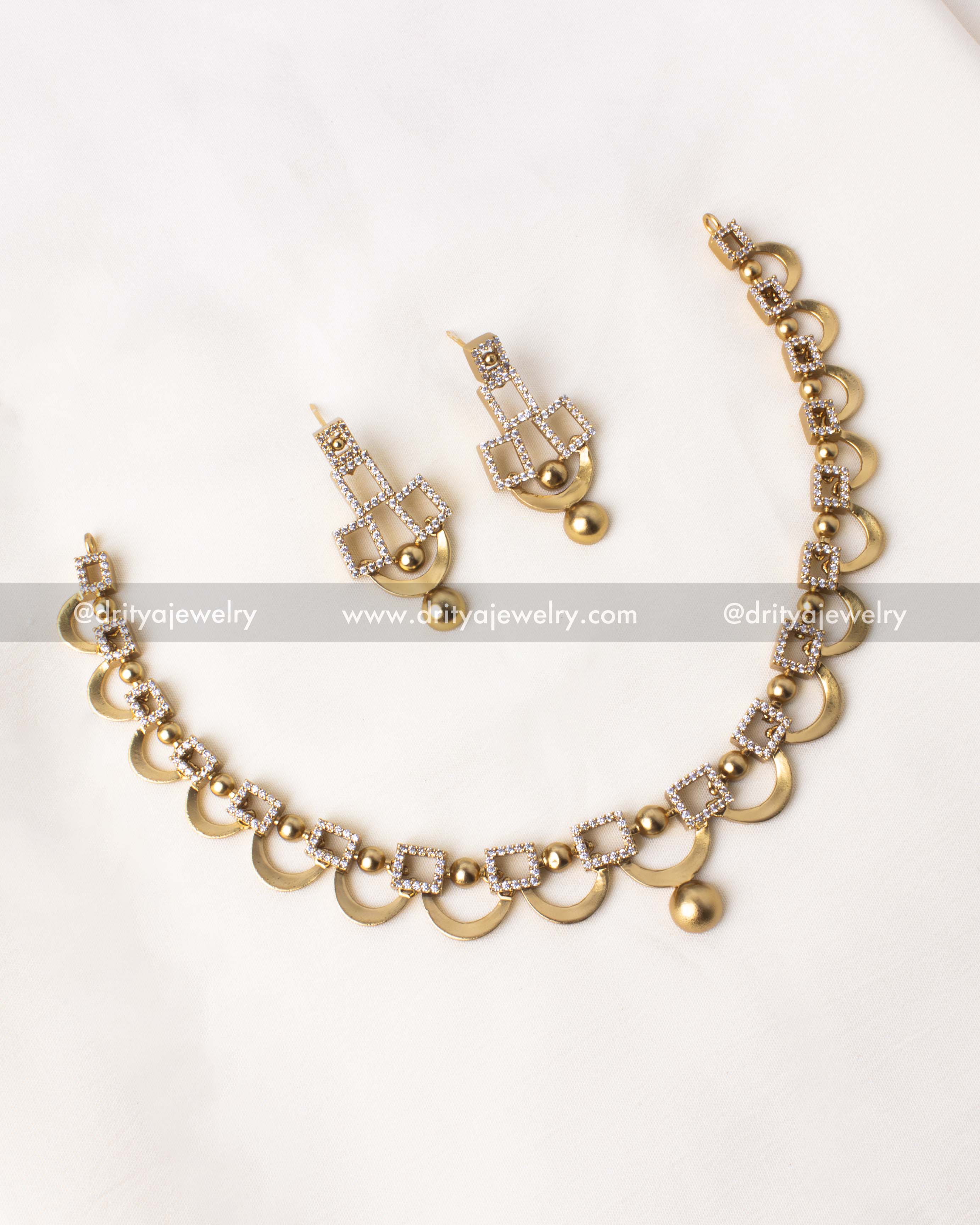 Golden short necklace set with geometric designs and CZ stones, paired with matching dangler earrings.