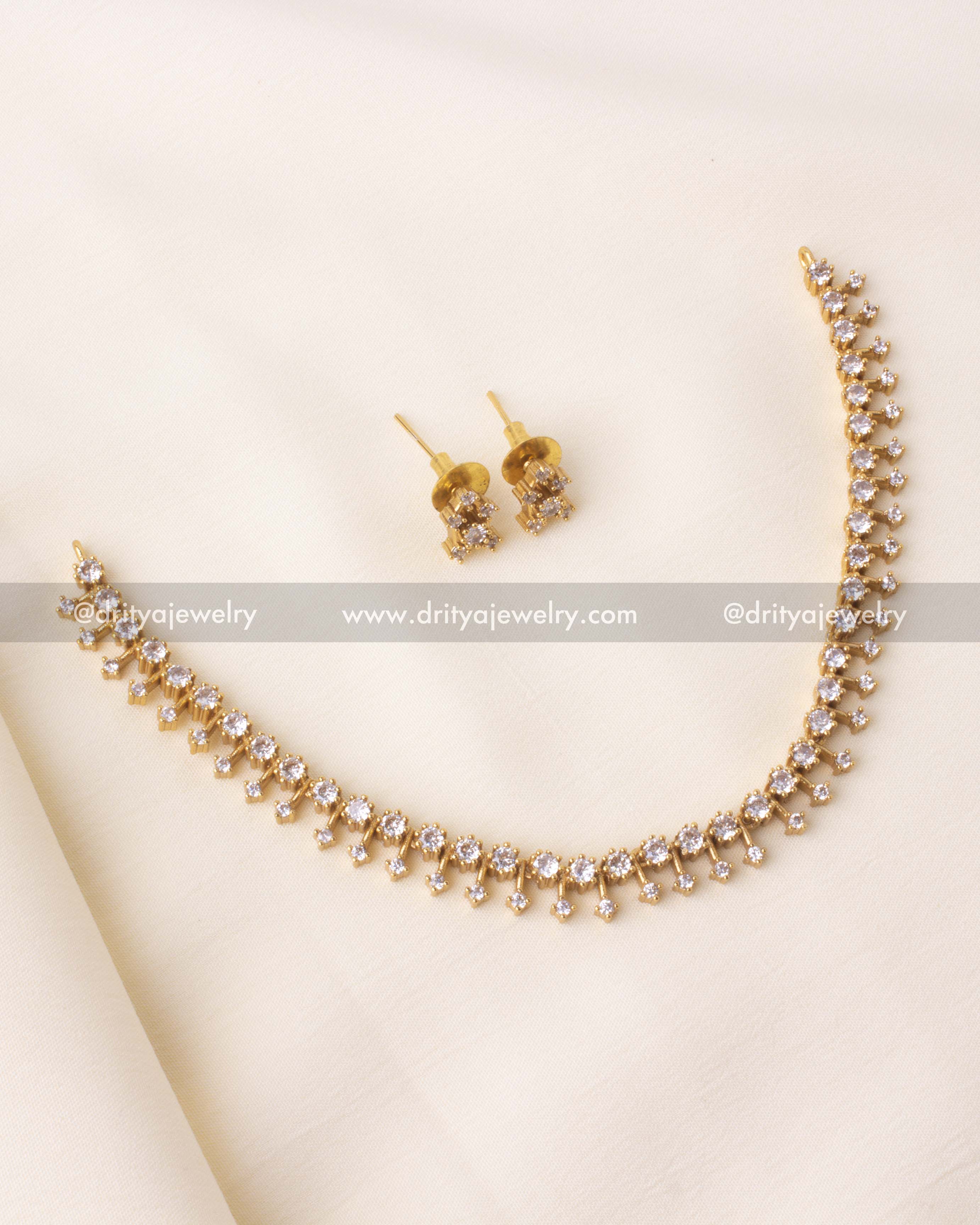 Close-up showing precise setting of shimmering CZ stones in a double-drop pattern on a gold-finish necklace.