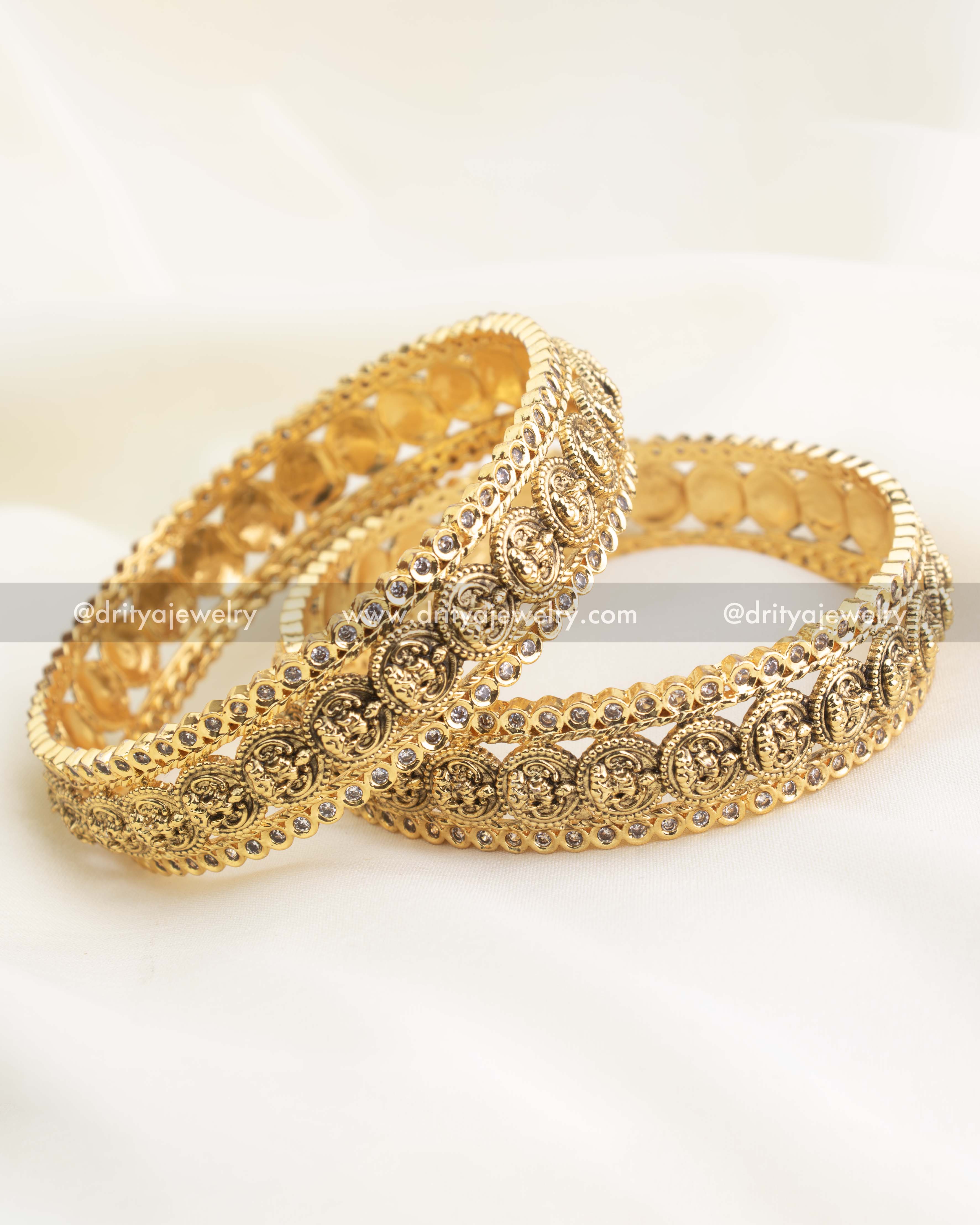 Side view of kasu coin bangles highlighting textured granulation and glossy high-gold polish.