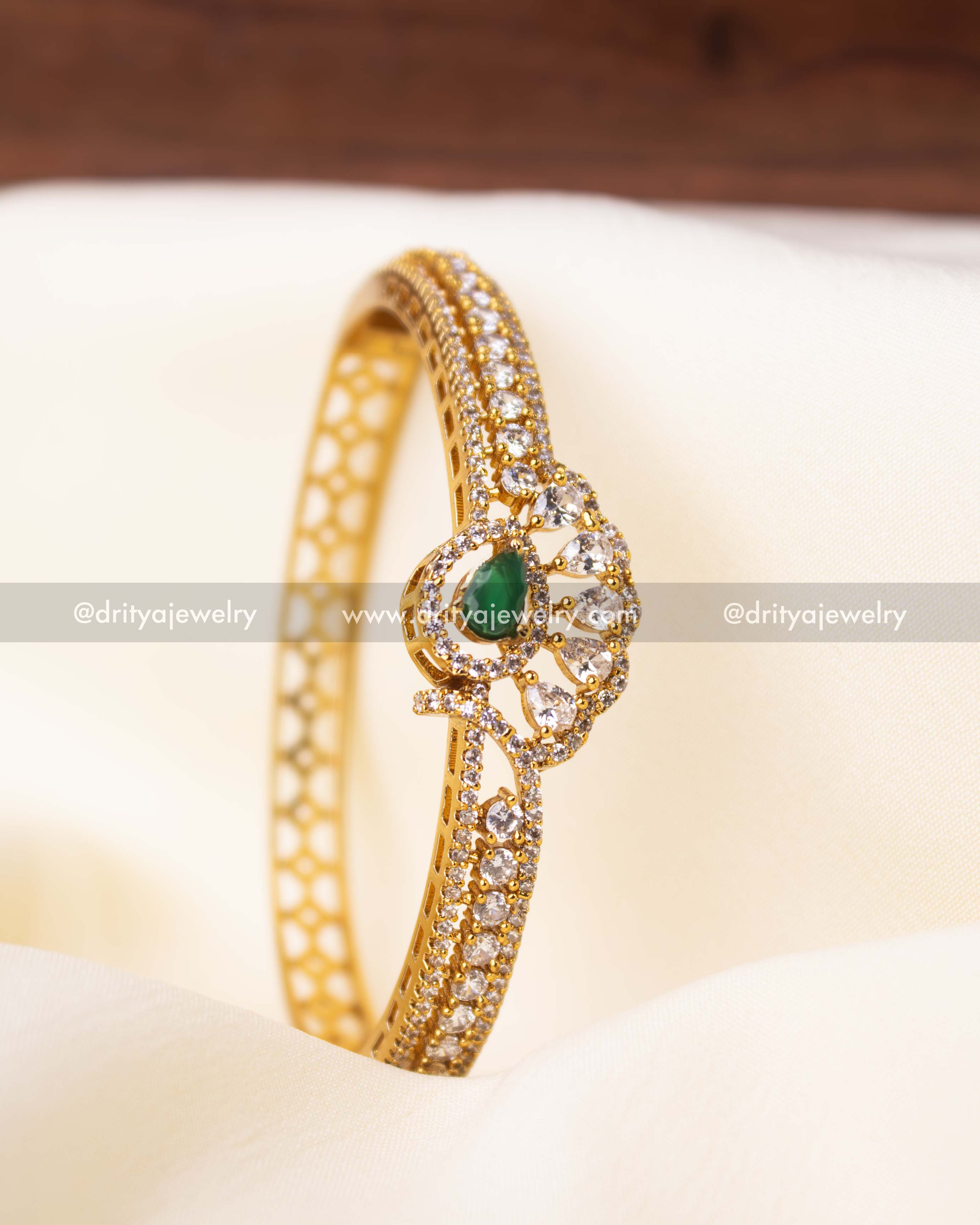 Gold-plated kada with double-layered CZ stones and green gemstone center.