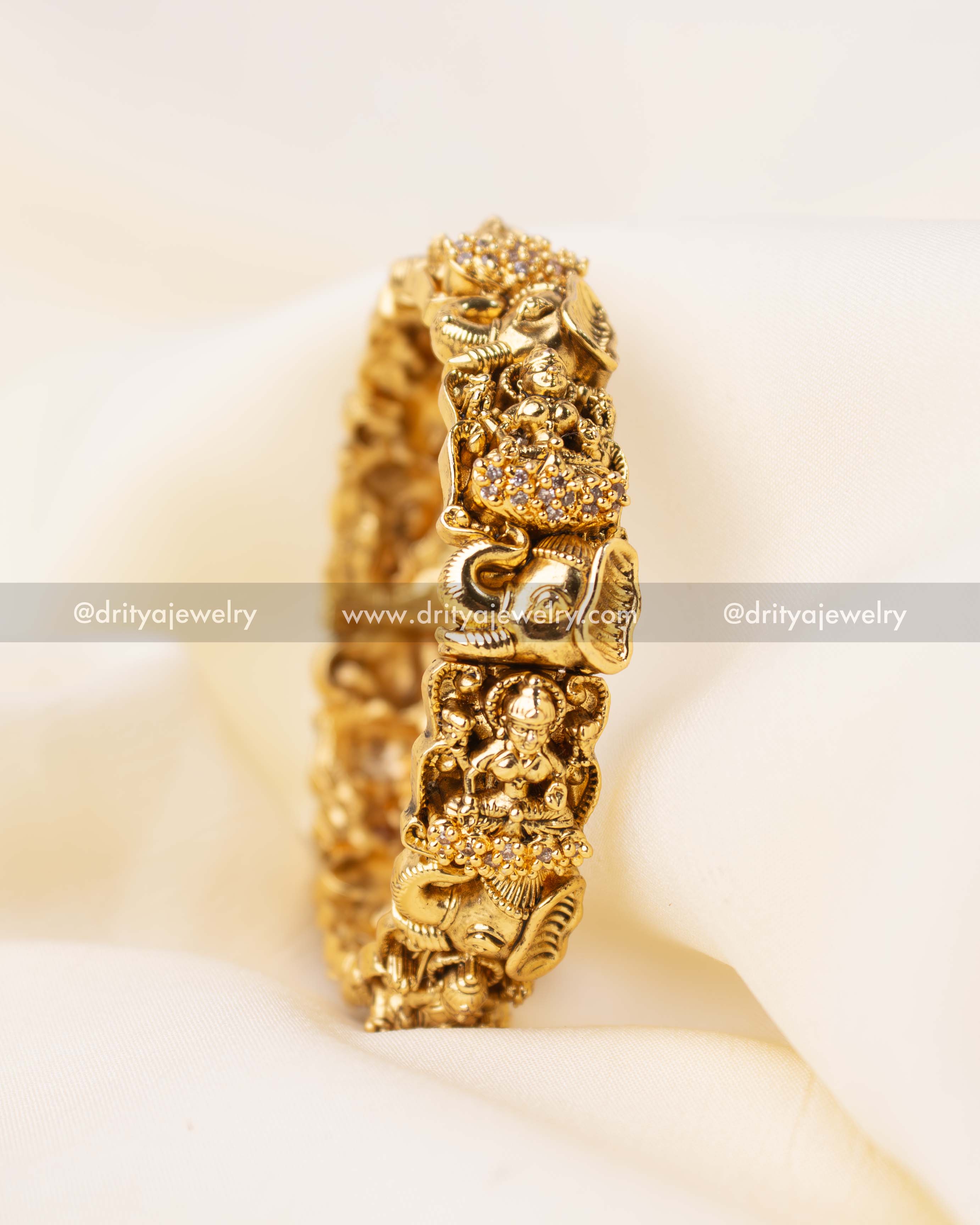 Detailed view of single Nakshi bangle with deity and floral carvings.