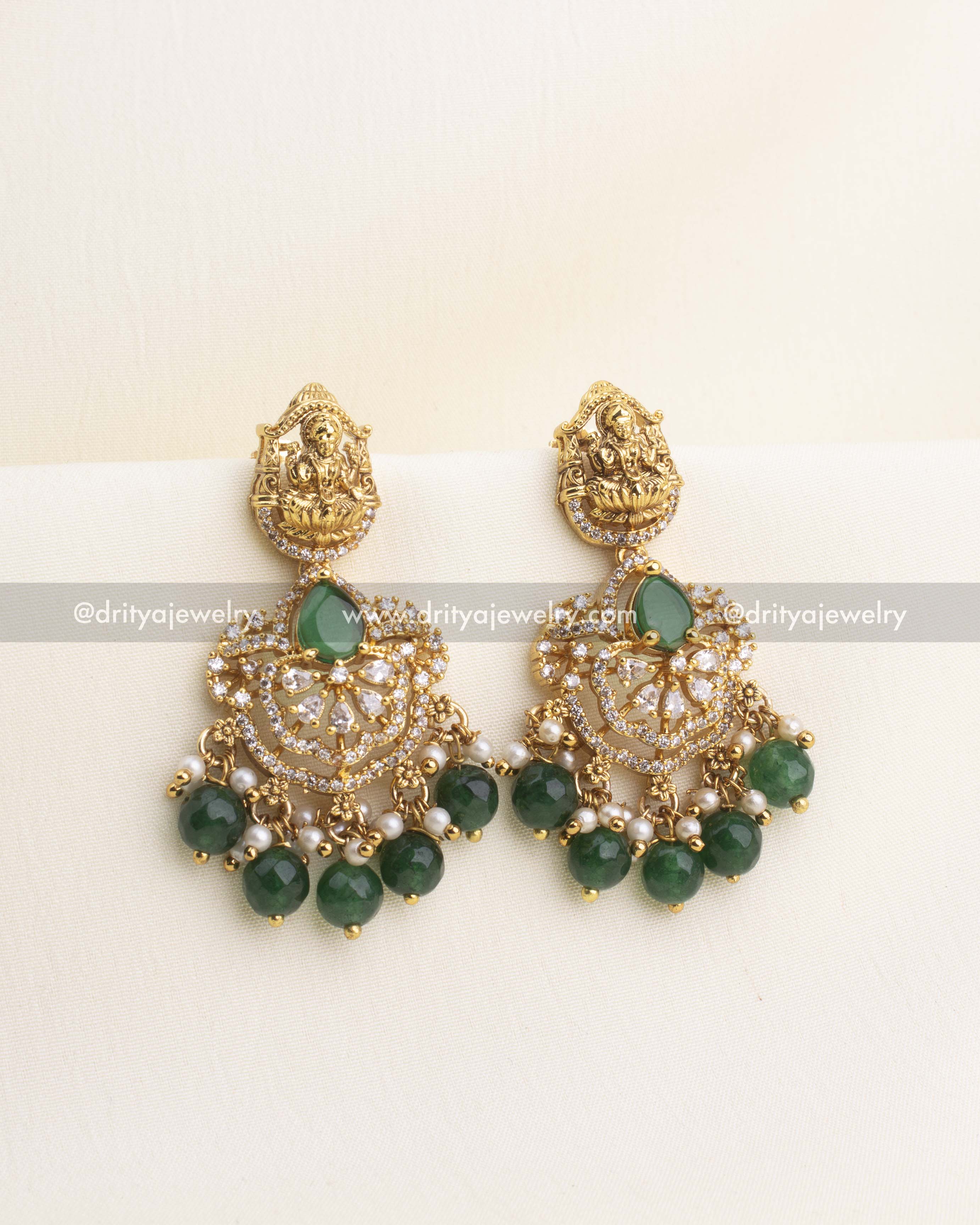 Gold temple earrings with nakshi Lakshmi tops, CZ stone work, and emerald green bead drops.