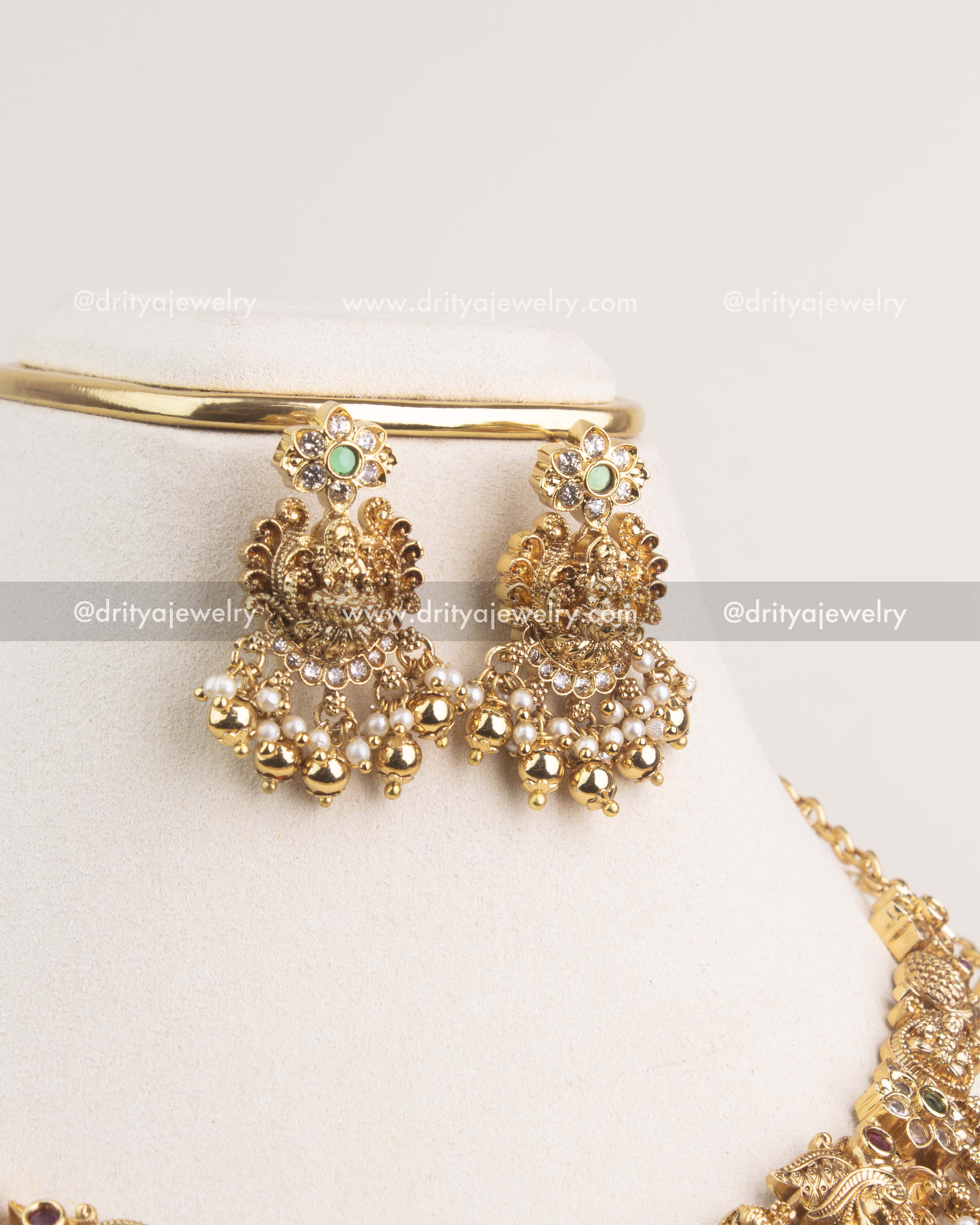 Antique gold temple jhumka earrings with floral tops and pearl bead hangings.