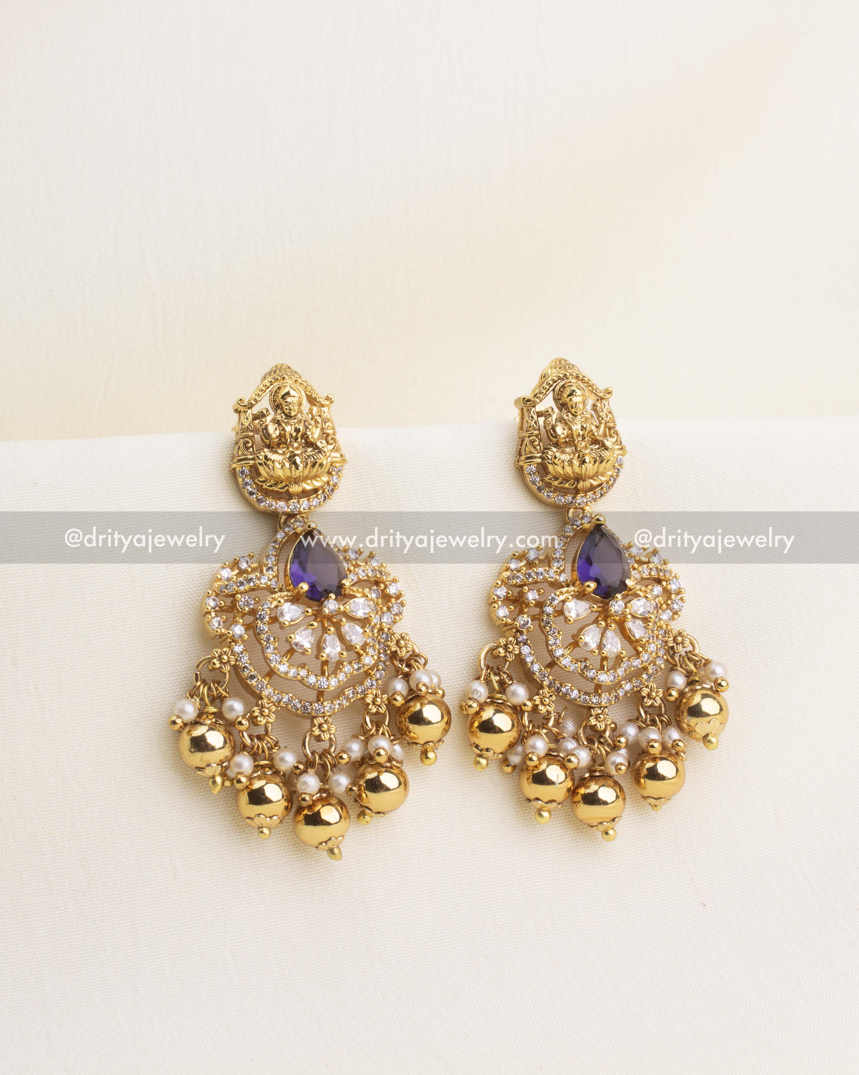 Purple stone temple earrings with nakshi Lakshmi tops, CZ embellishments, and golden bead hangings.
