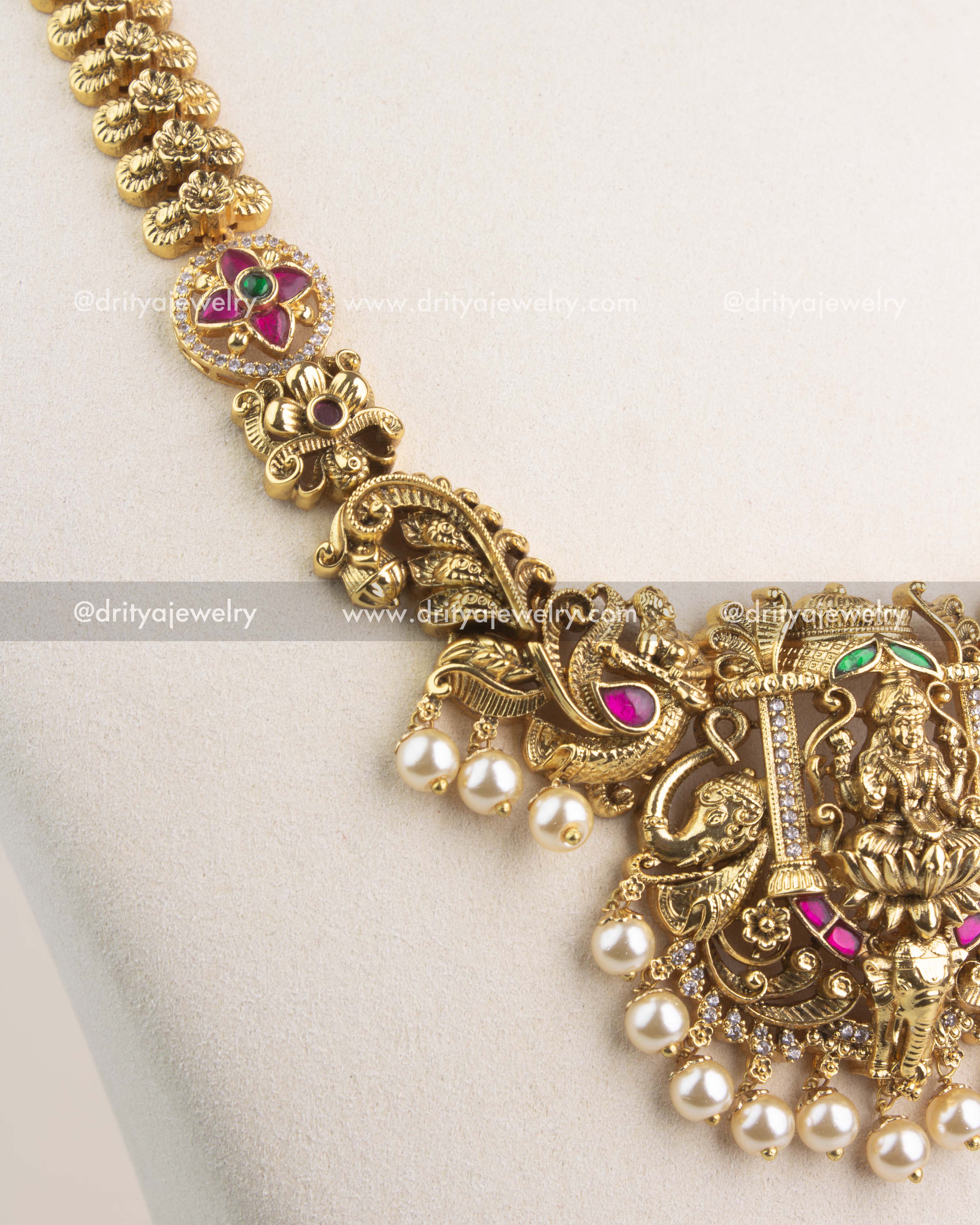 Close-up of peacock and floral motifs with antique gold polish and Kemp stone accents.