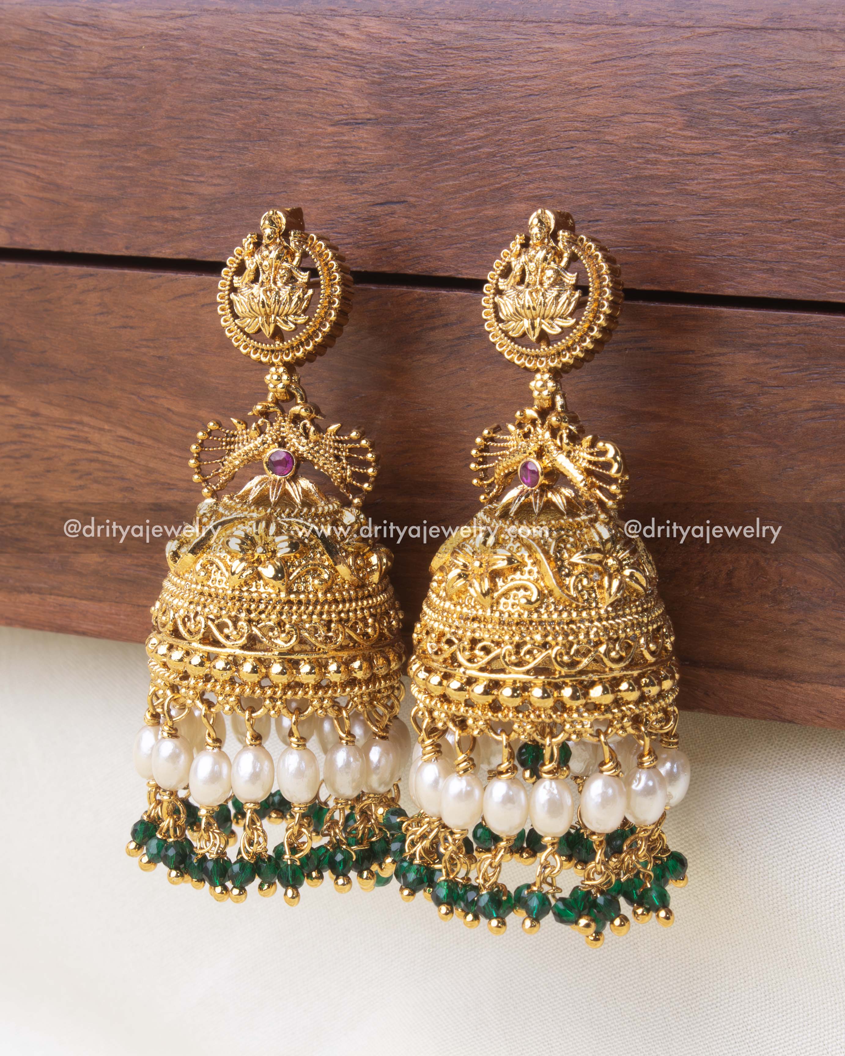 Gold-plated temple Jhumka earrings featuring pearl drops and green crystal beads.