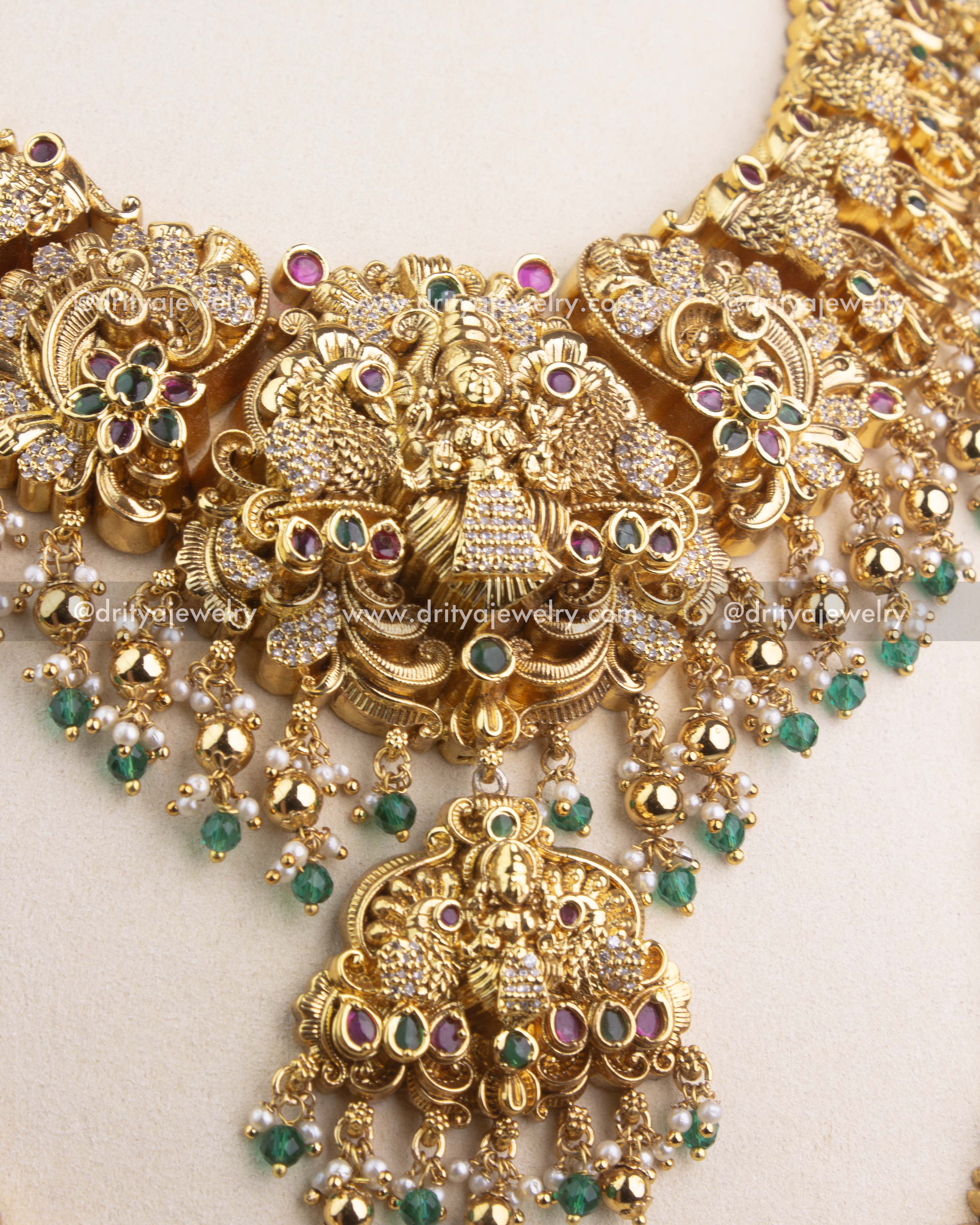 Close-up of Nakshi temple long necklace with Lakshmi pendant, emerald green stones and CZ accents.