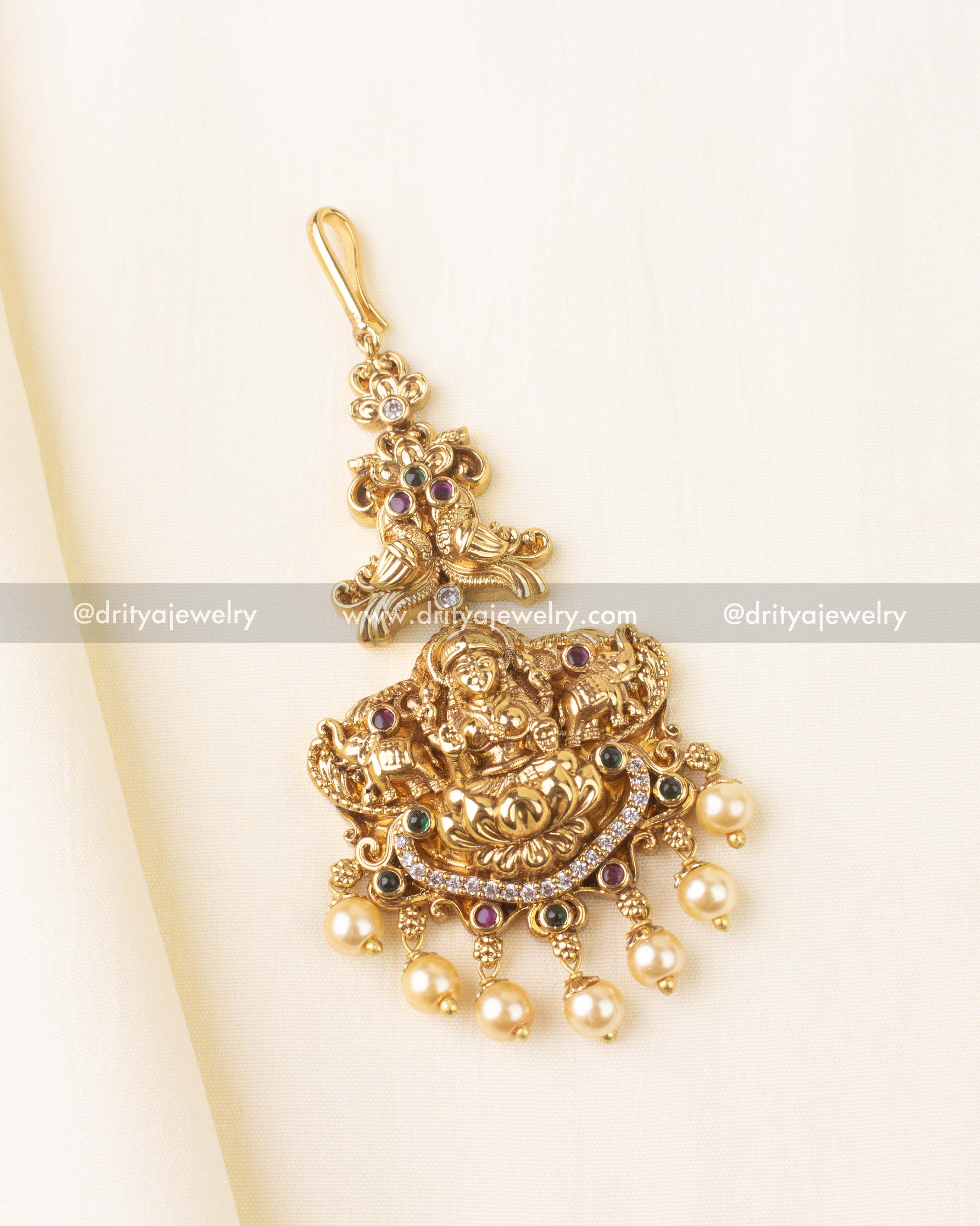 Antique gold temple maang tikka featuring Lakshmi Devi motif and pearl drops
