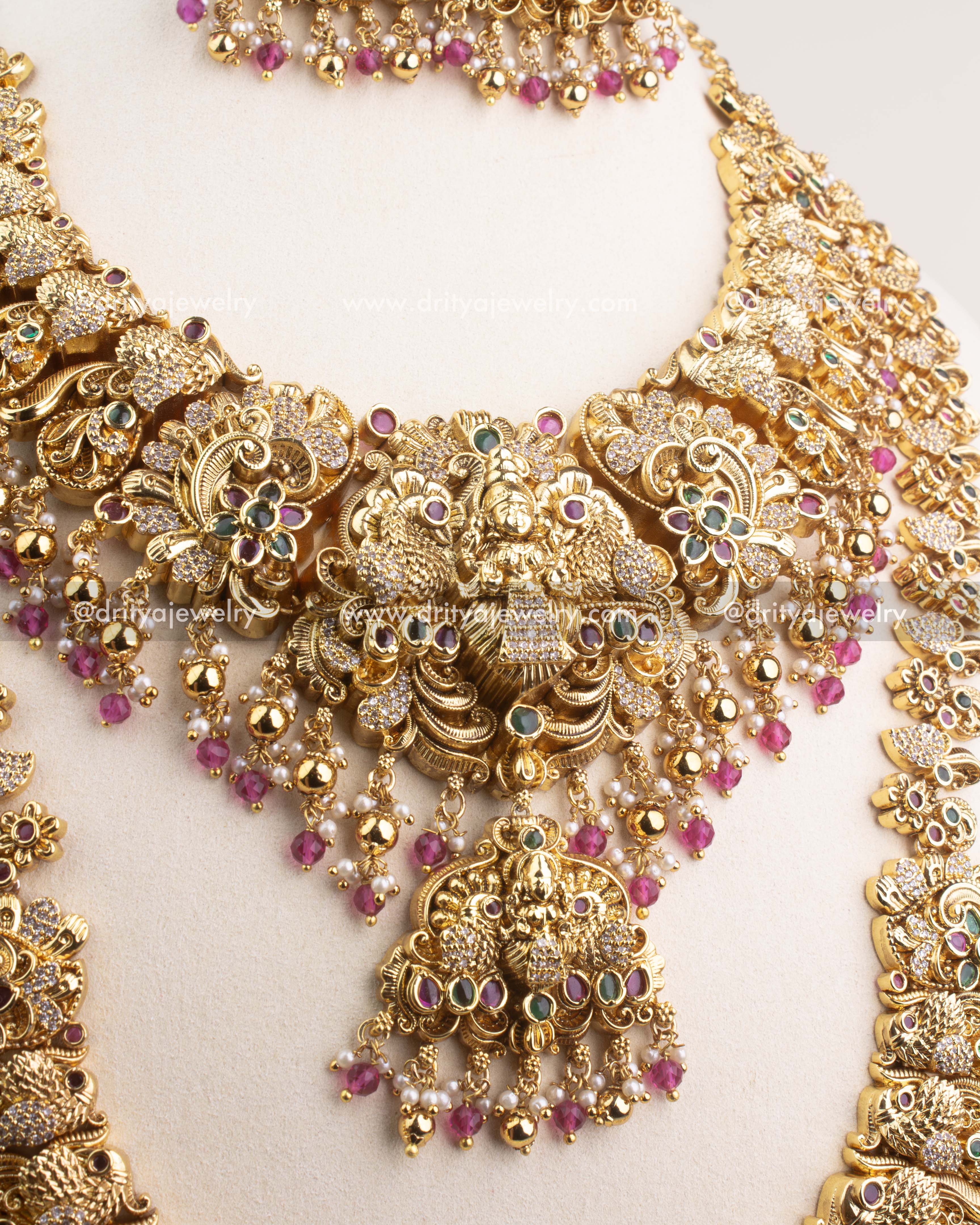 Close-up of Nakshi temple necklace with CZ stones and ruby pink bead hangings.