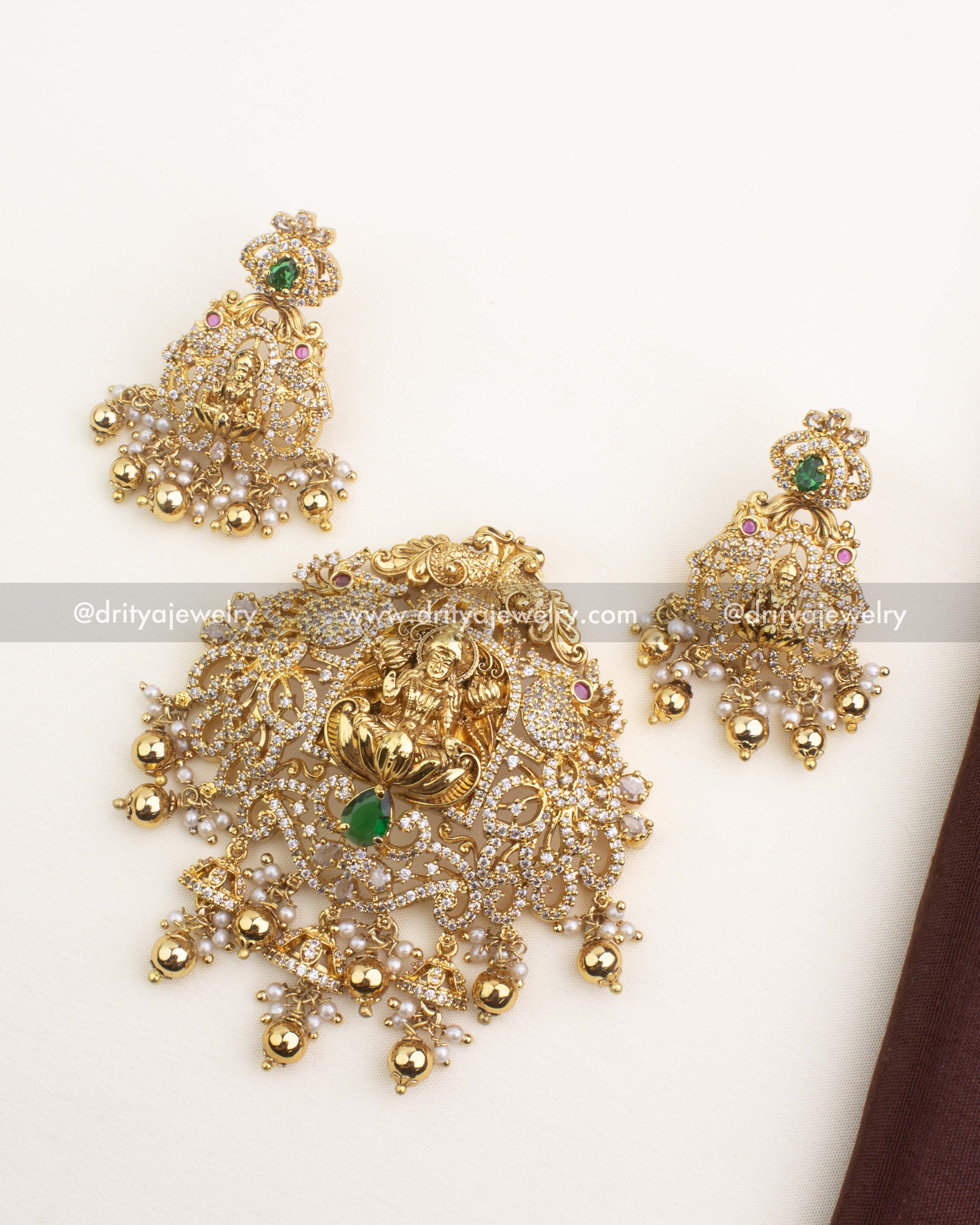 Premium gold-plated temple jewelry pendant set with Lakshmi motif, CZ stones, and green teardrop center stone.