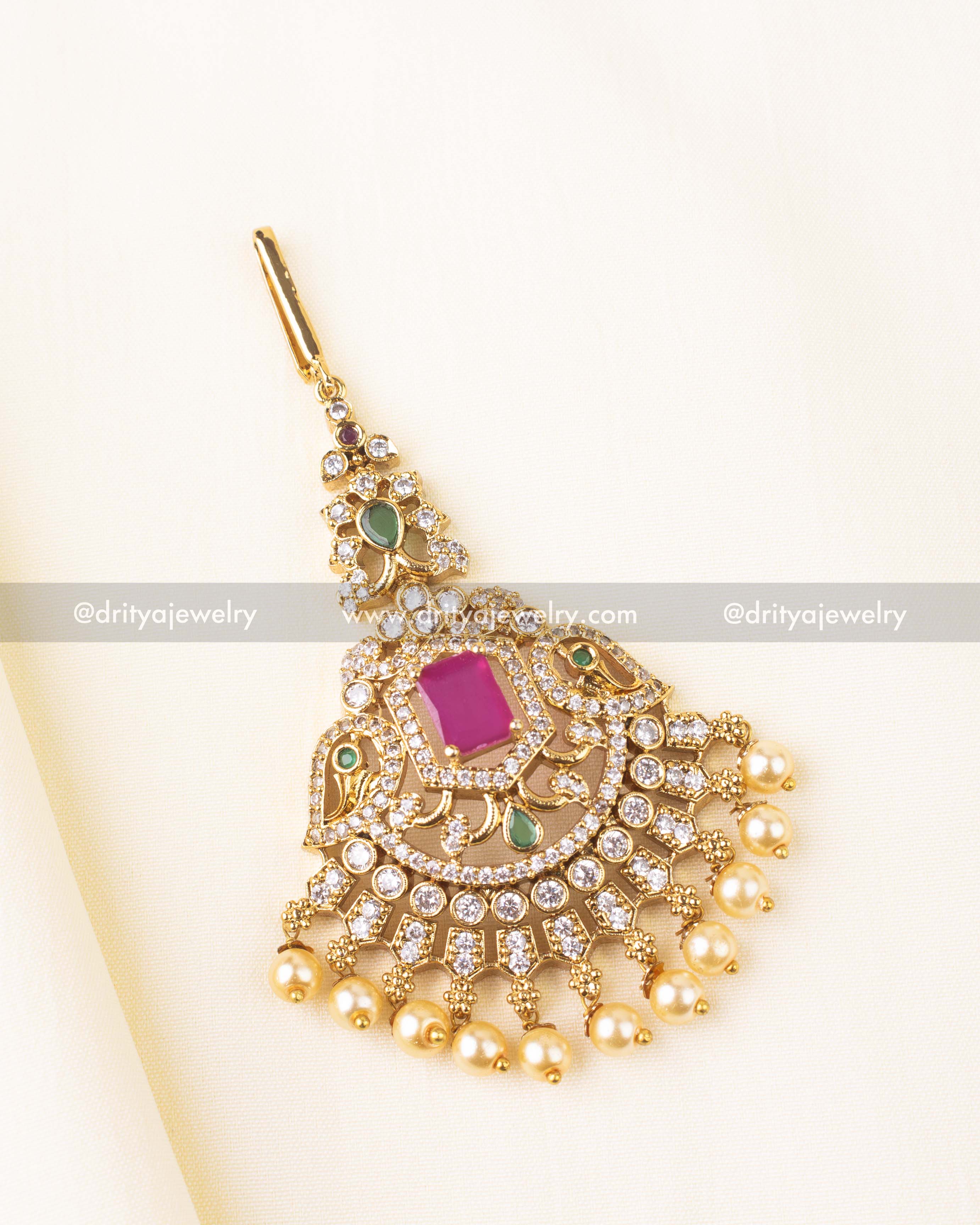 Gold-plated Maang Tikka featuring a pink center stone, CZ embellishments, and pearl hangings