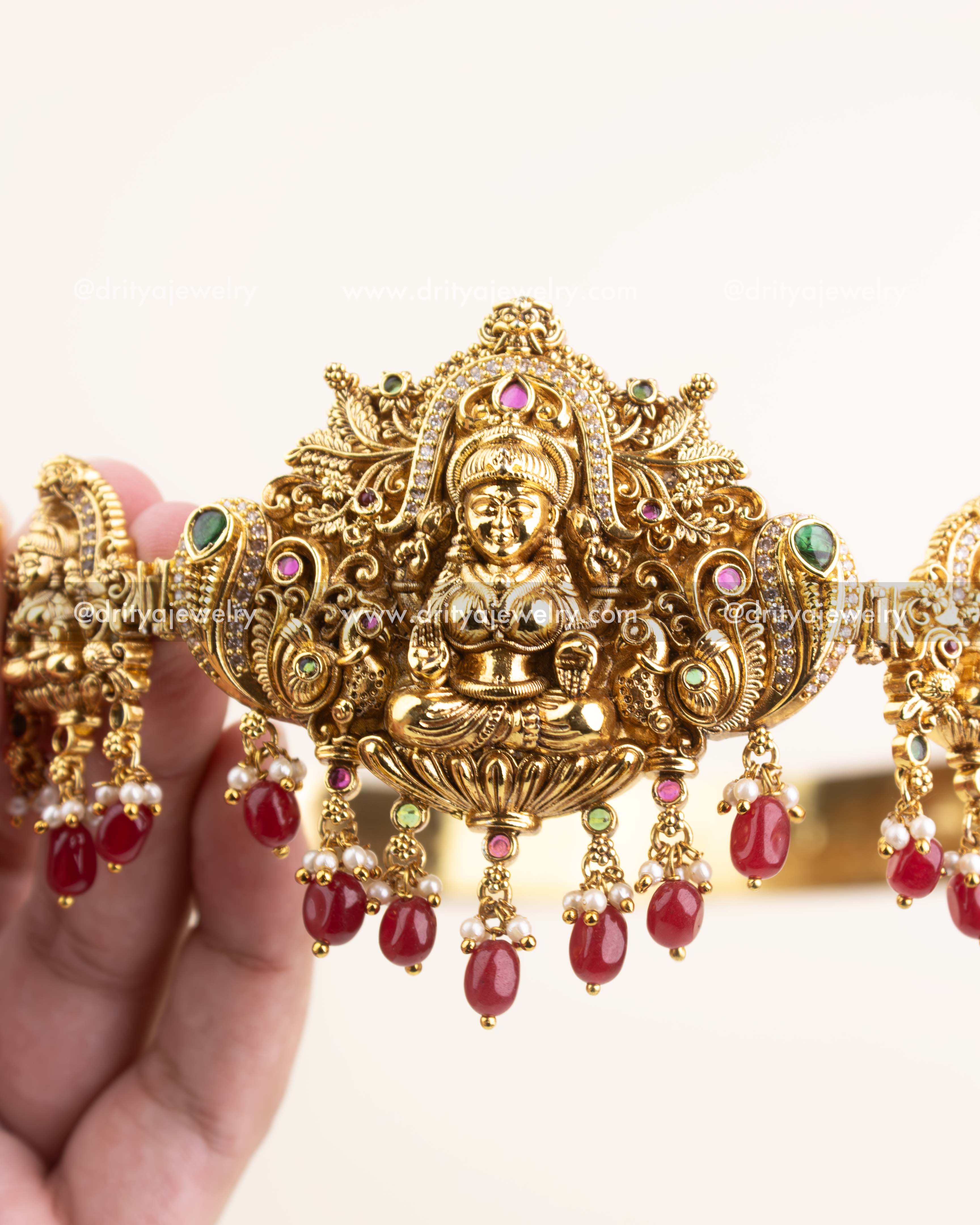 Detailed close-up of Lakshmi motif with peacock carvings and ruby-emerald accents.