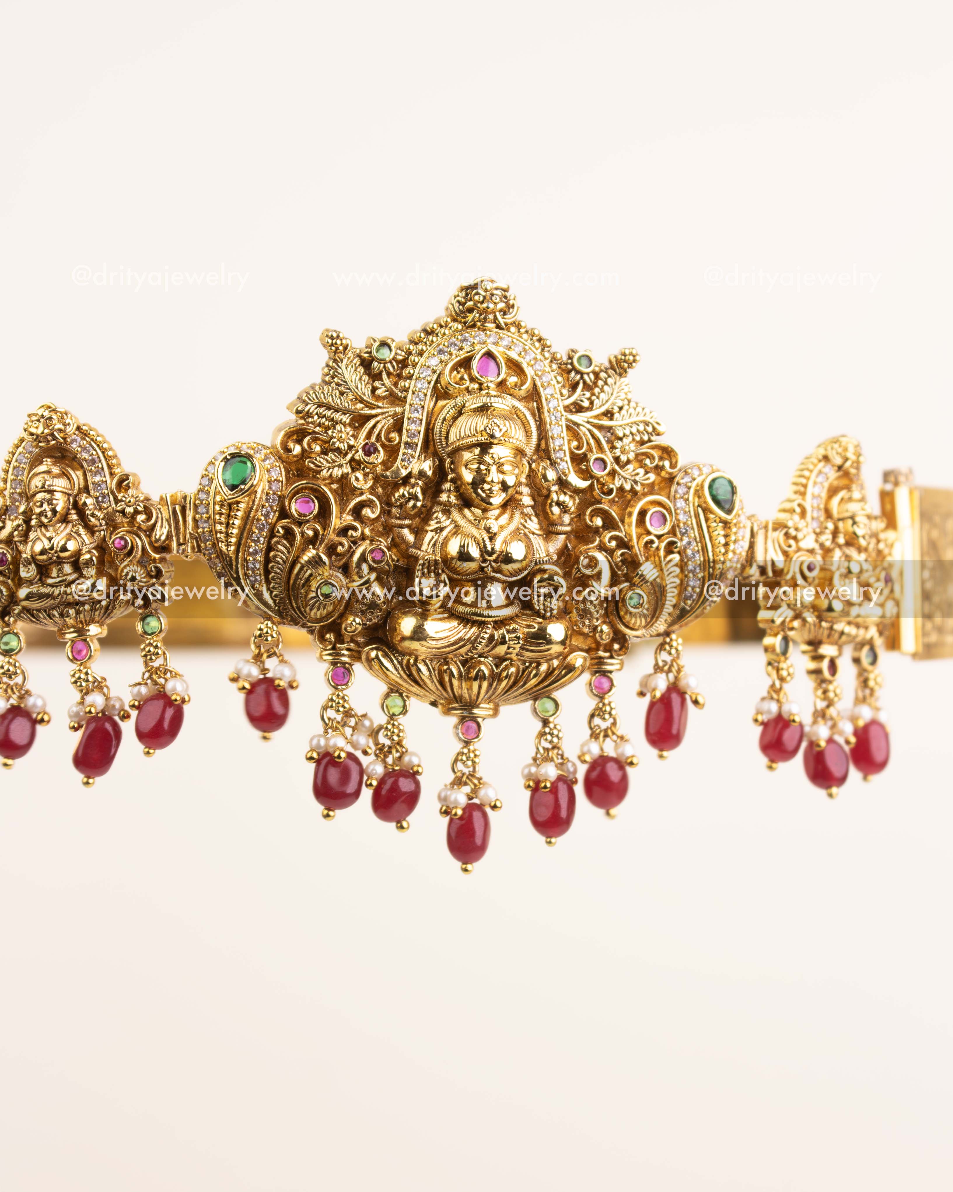 Detailed close-up of Lakshmi motif with peacock carvings and ruby-emerald accents.