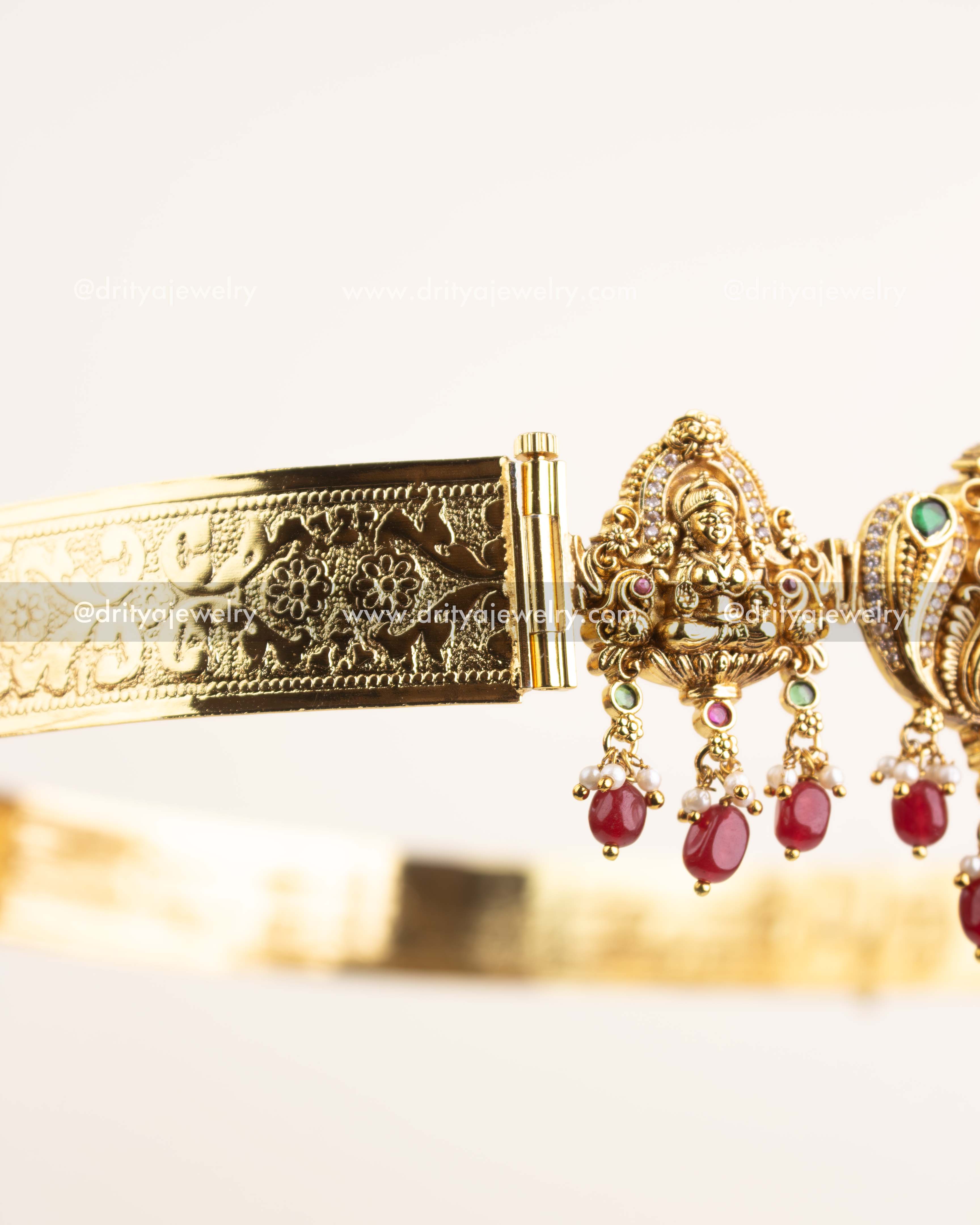 Side view showing embossed floral detailing and antique gold finish.