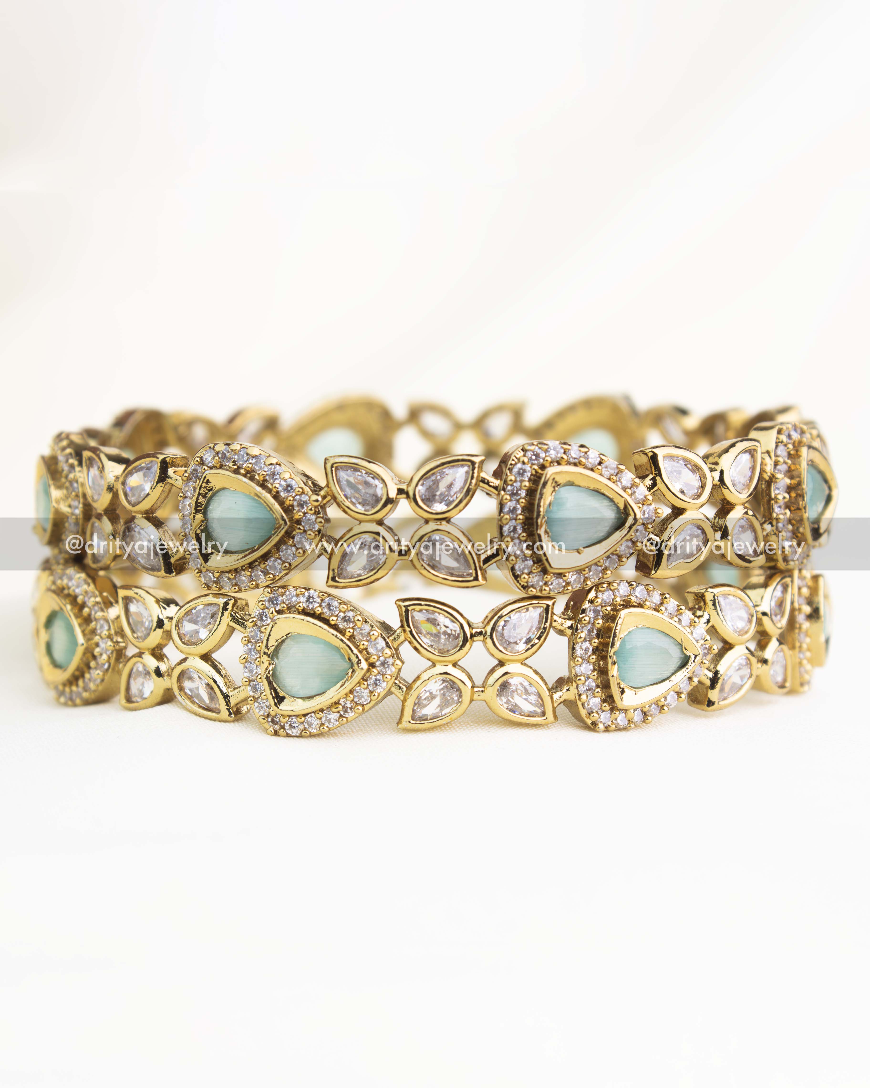 Mint green AD stone Victorian bangles with teardrop design and intricate gold finish from Dritya Jewelry.