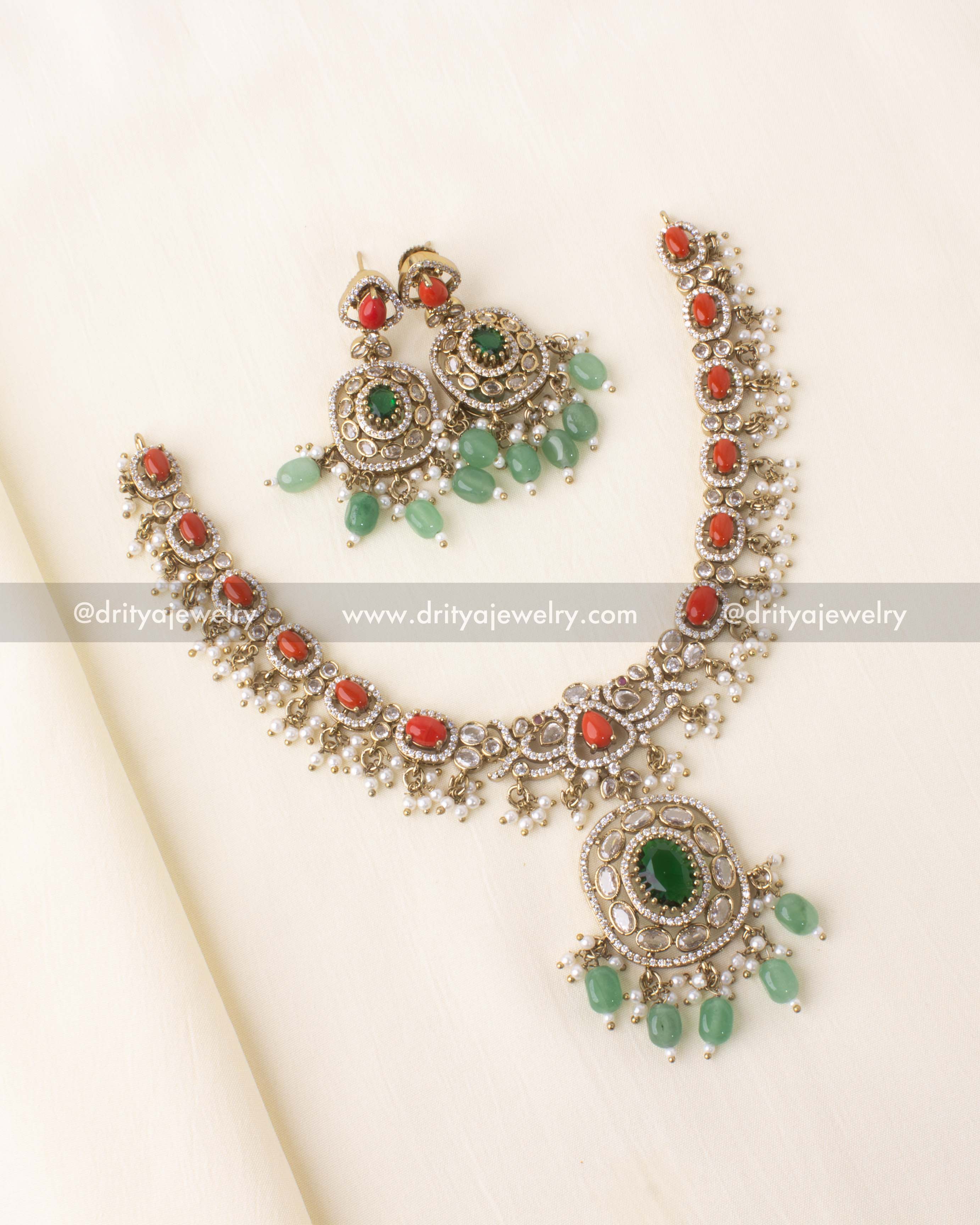 Short necklace with coral red stones, green pendant, and pearl bead clusters in Victorian polish.