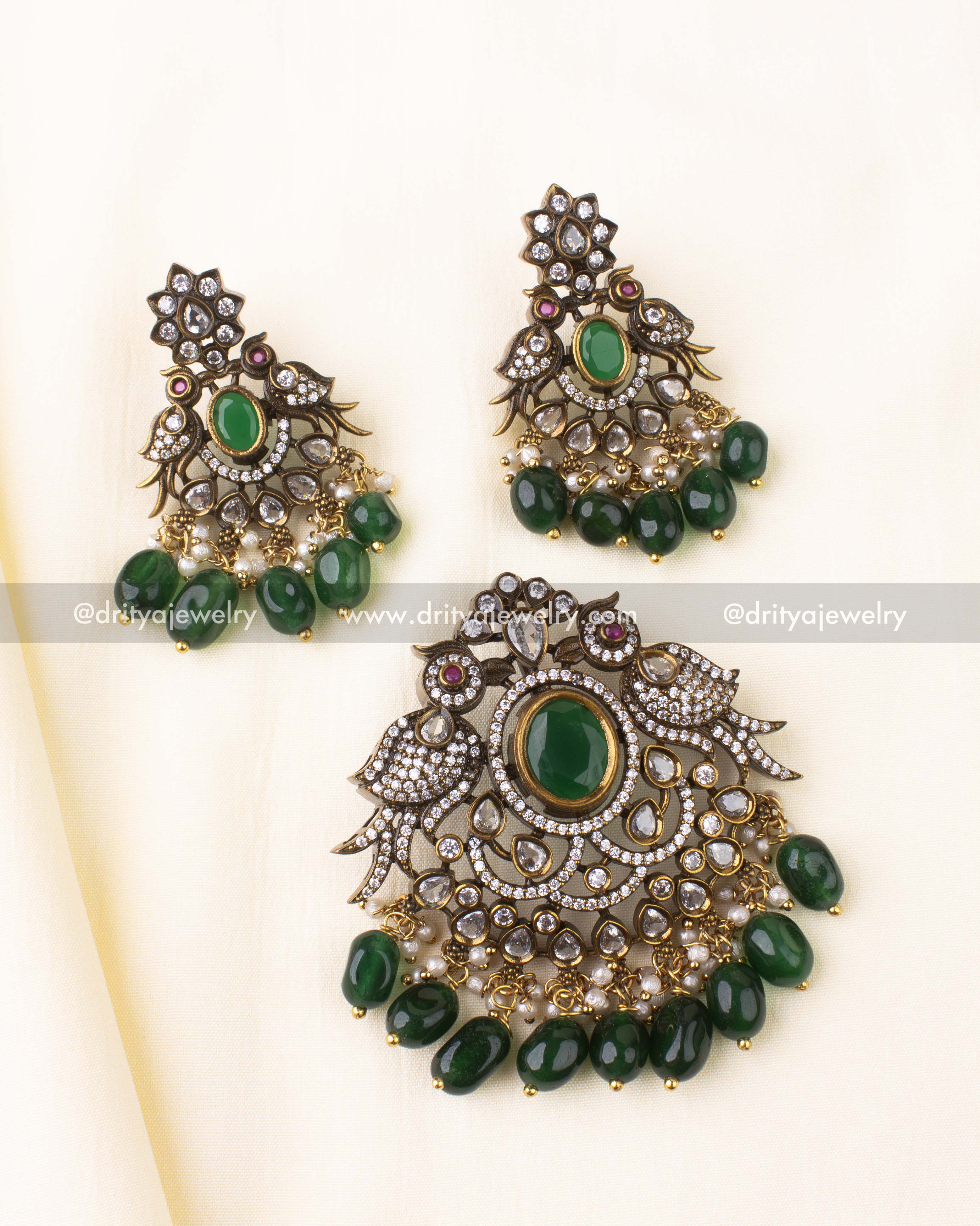 Antique gold-plated Victorian pendant set with green centerpiece and peacock detailing.