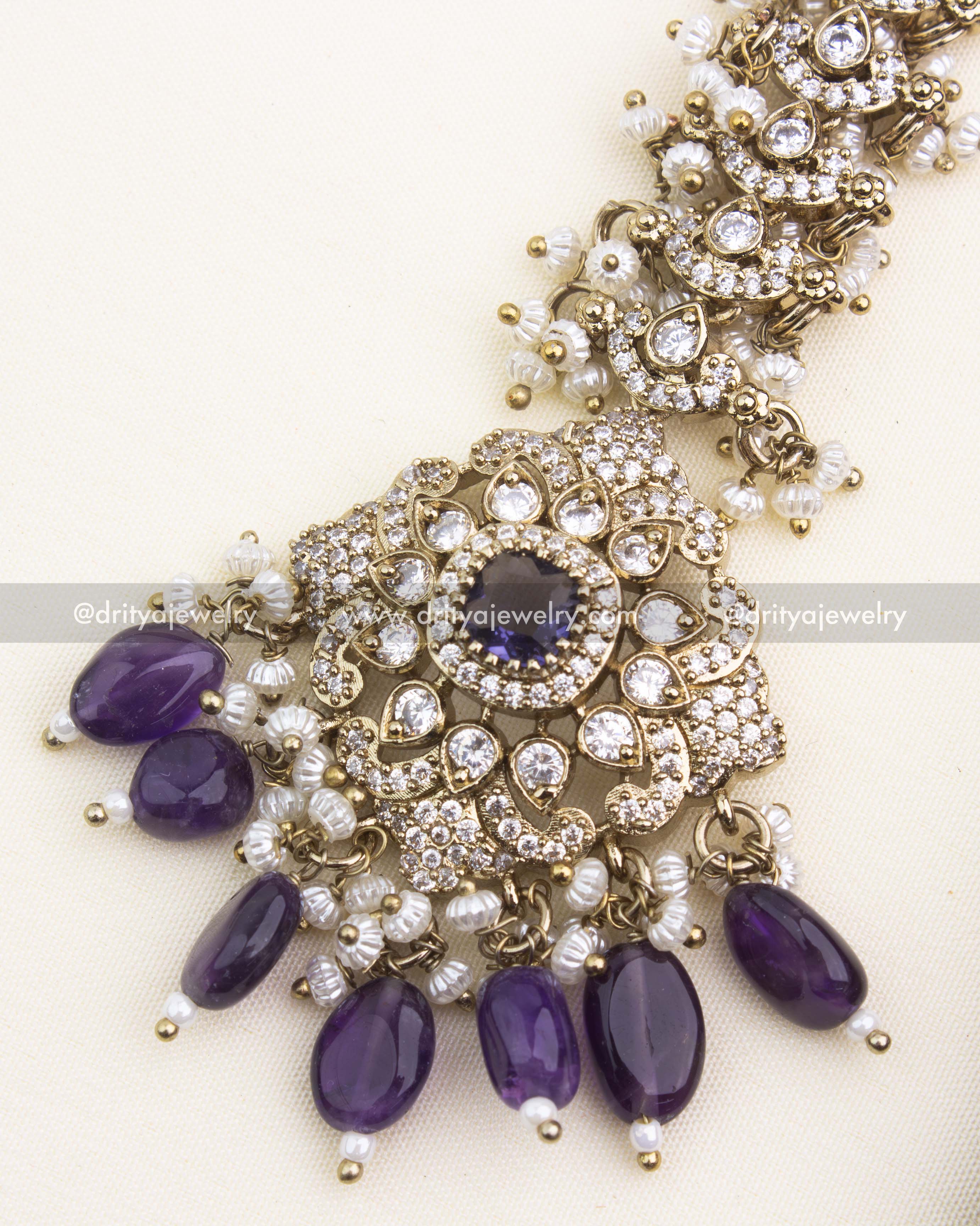 Close-up of purple Victorian maang tikka featuring oval drops and intricate stone setting.