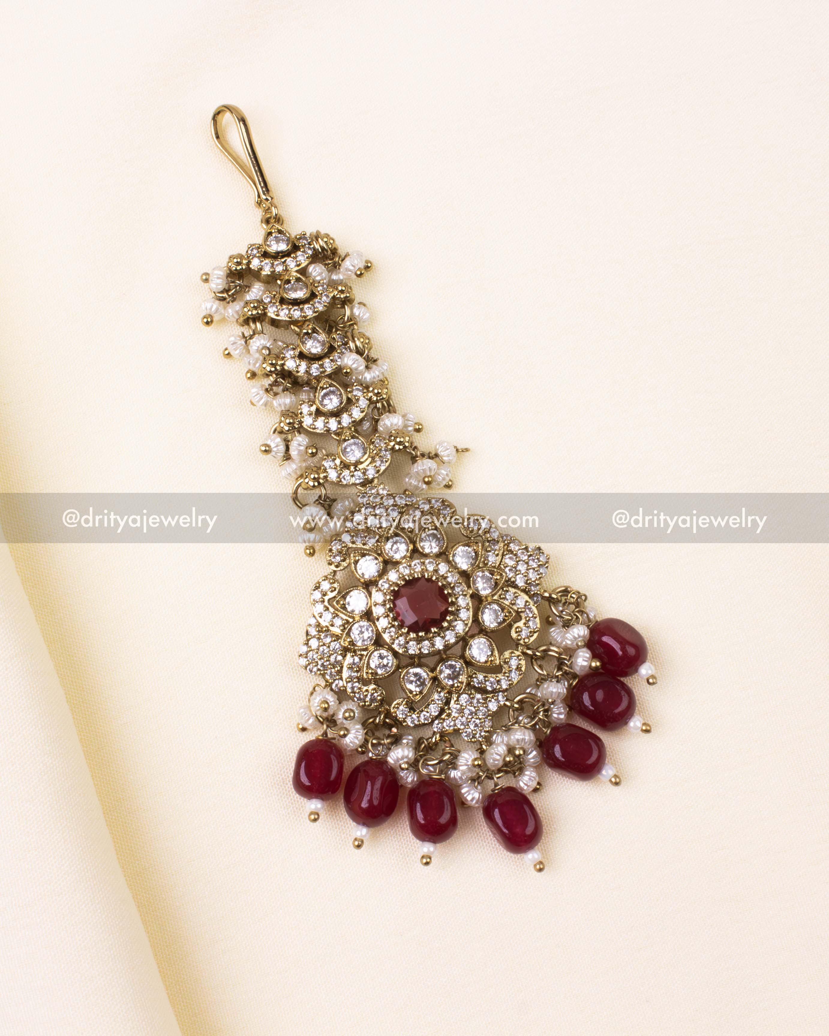 Red-stone Maang Tikka with antique floral design and pearl danglers.