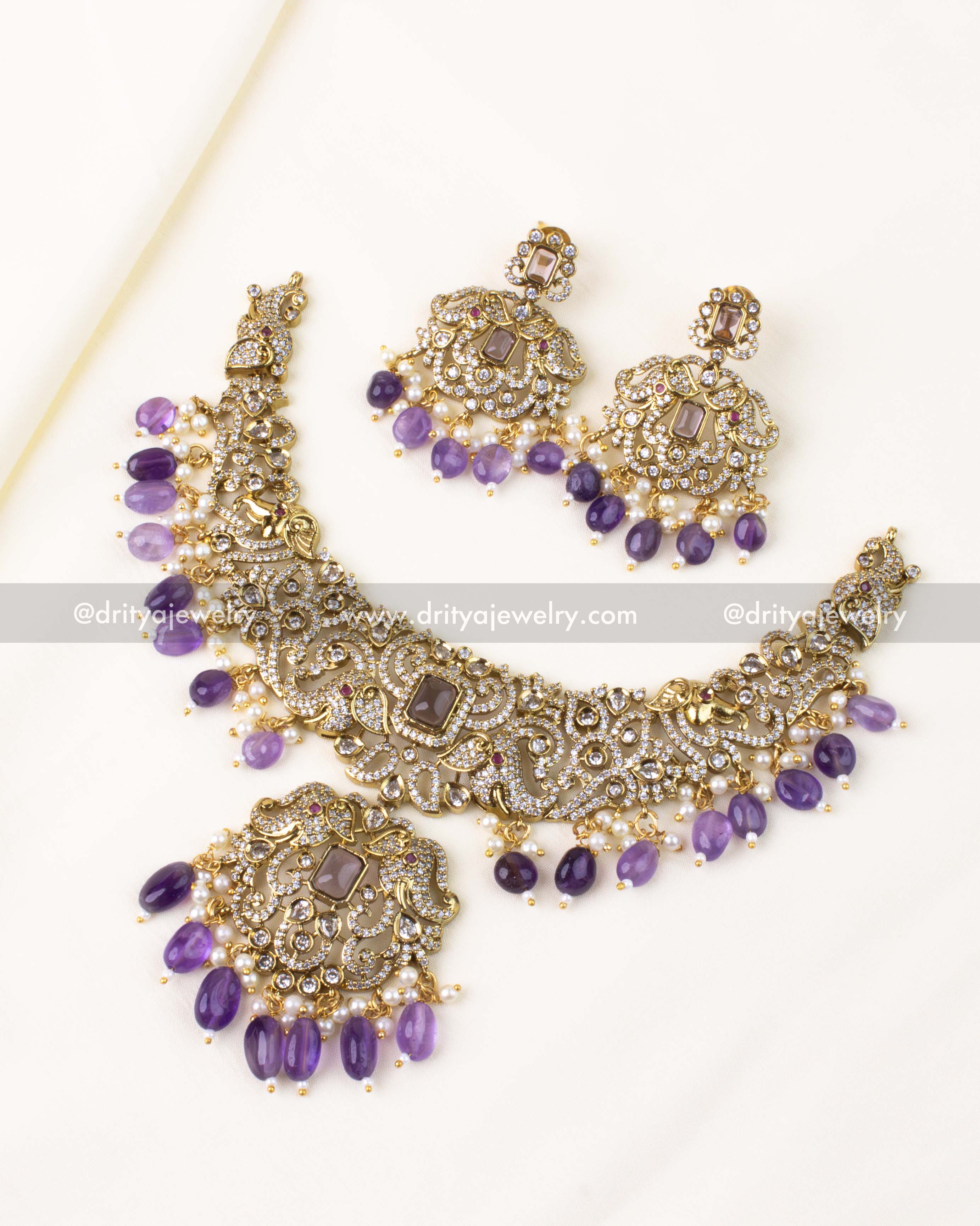 Antique Victorian necklace set with purple rectangular stones, pearl drops, and elegant motifs.