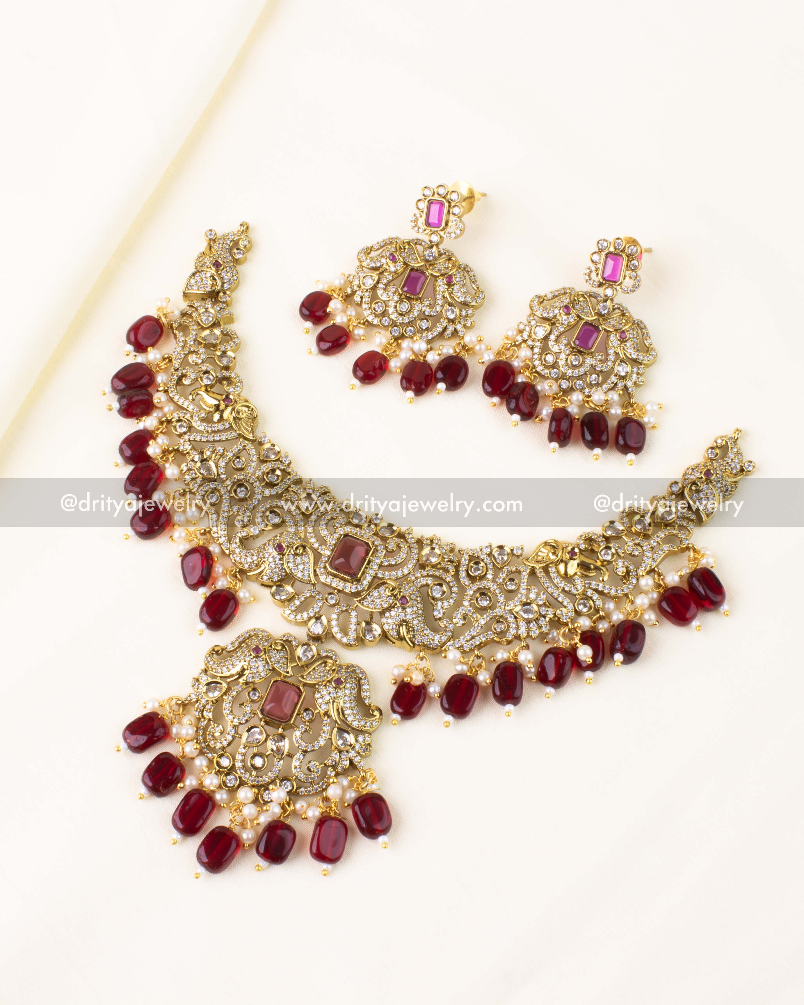 Elegant short necklace set with red center stones, AD sparkle, and antique gold finish.