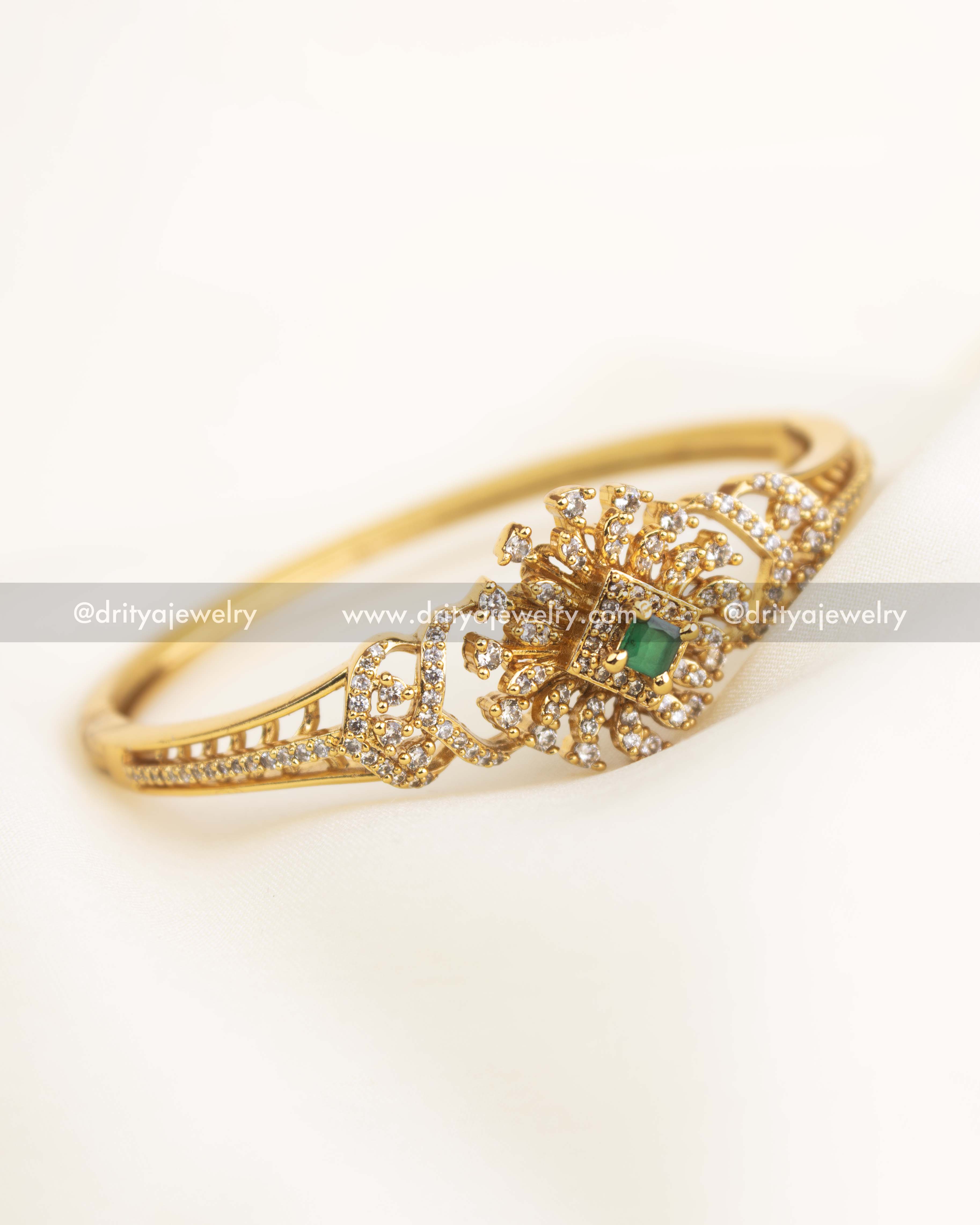 Close-up of floral CZ setting with emerald green square stone at the center.