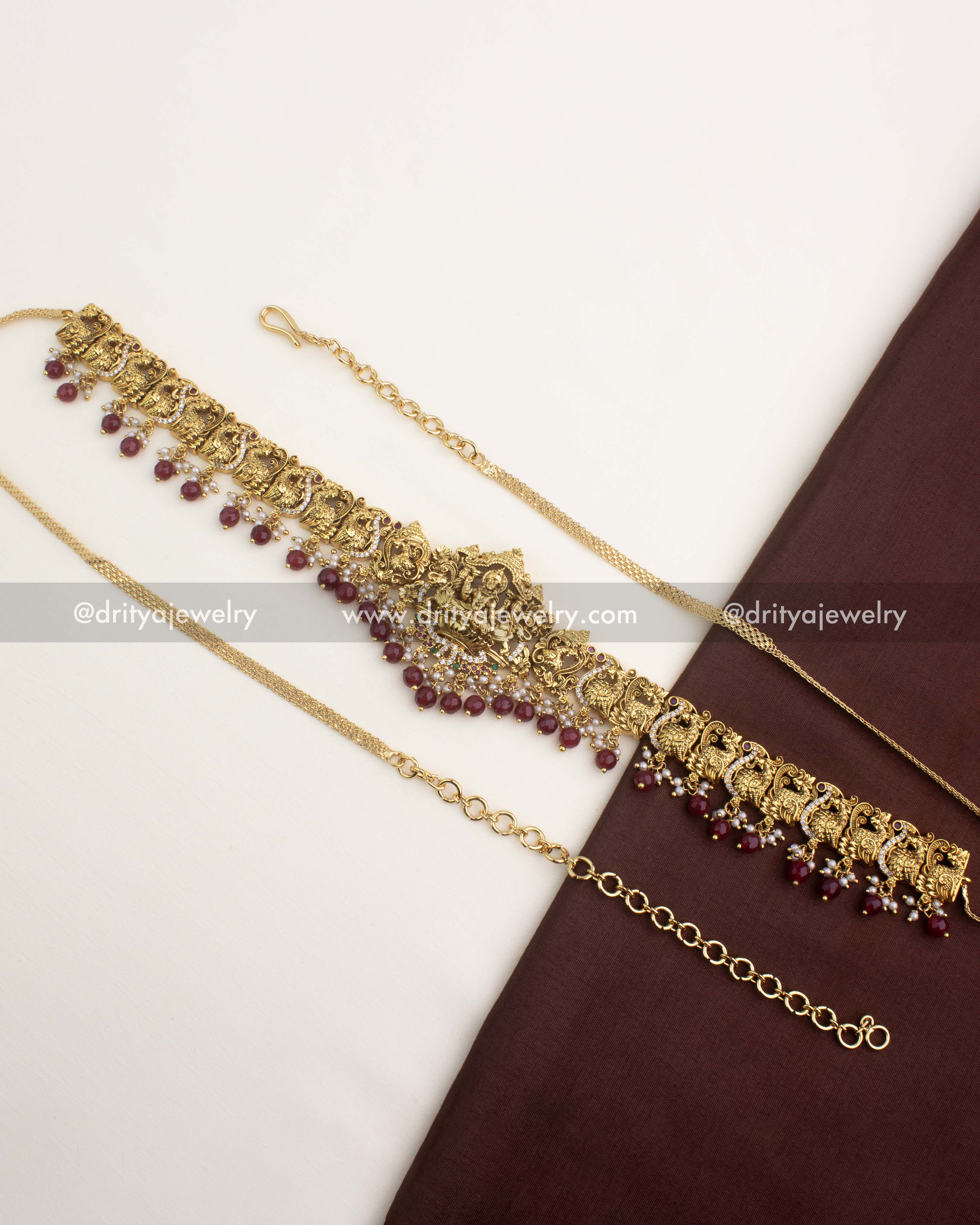 Premium temple hip chain with ruby red bead hangings, peacock motifs, and Lakshmi pendant.