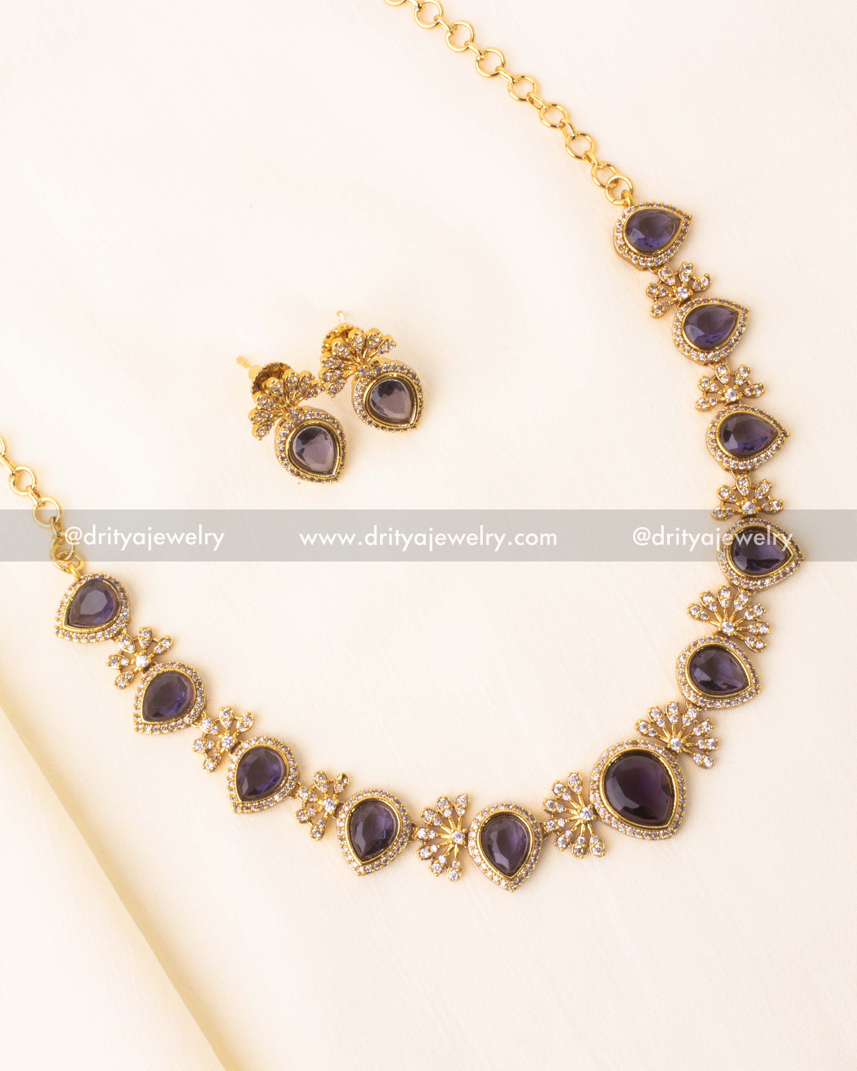 Short necklace set with violet teardrop stones and diamond accents in gold plating.