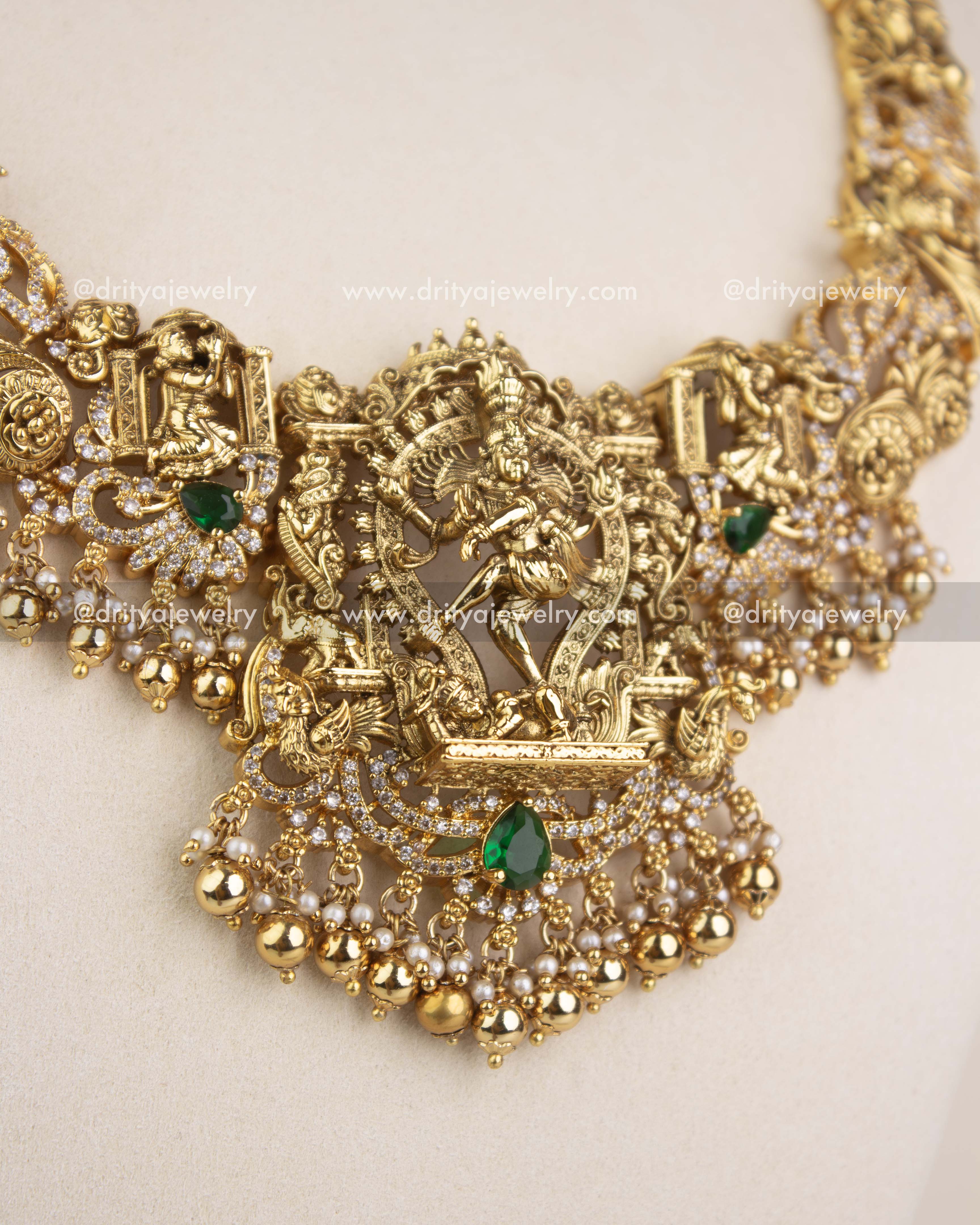 Detailed close-up of Nataraja pendant with emerald stones, CZ work, and pearl clusters.